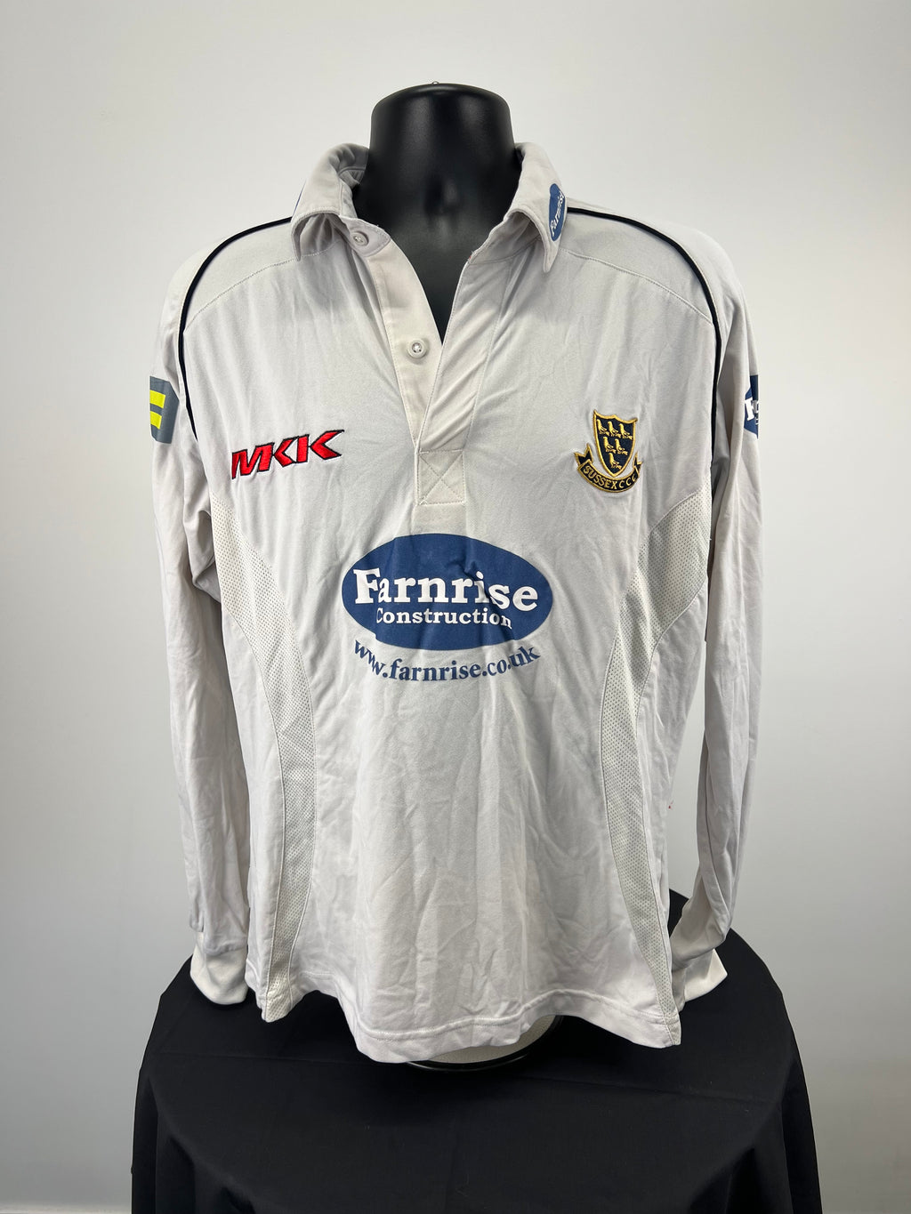 Front view of white long-sleeve Sussex CCC cricket jersey with Farnrise sponsor and club crest