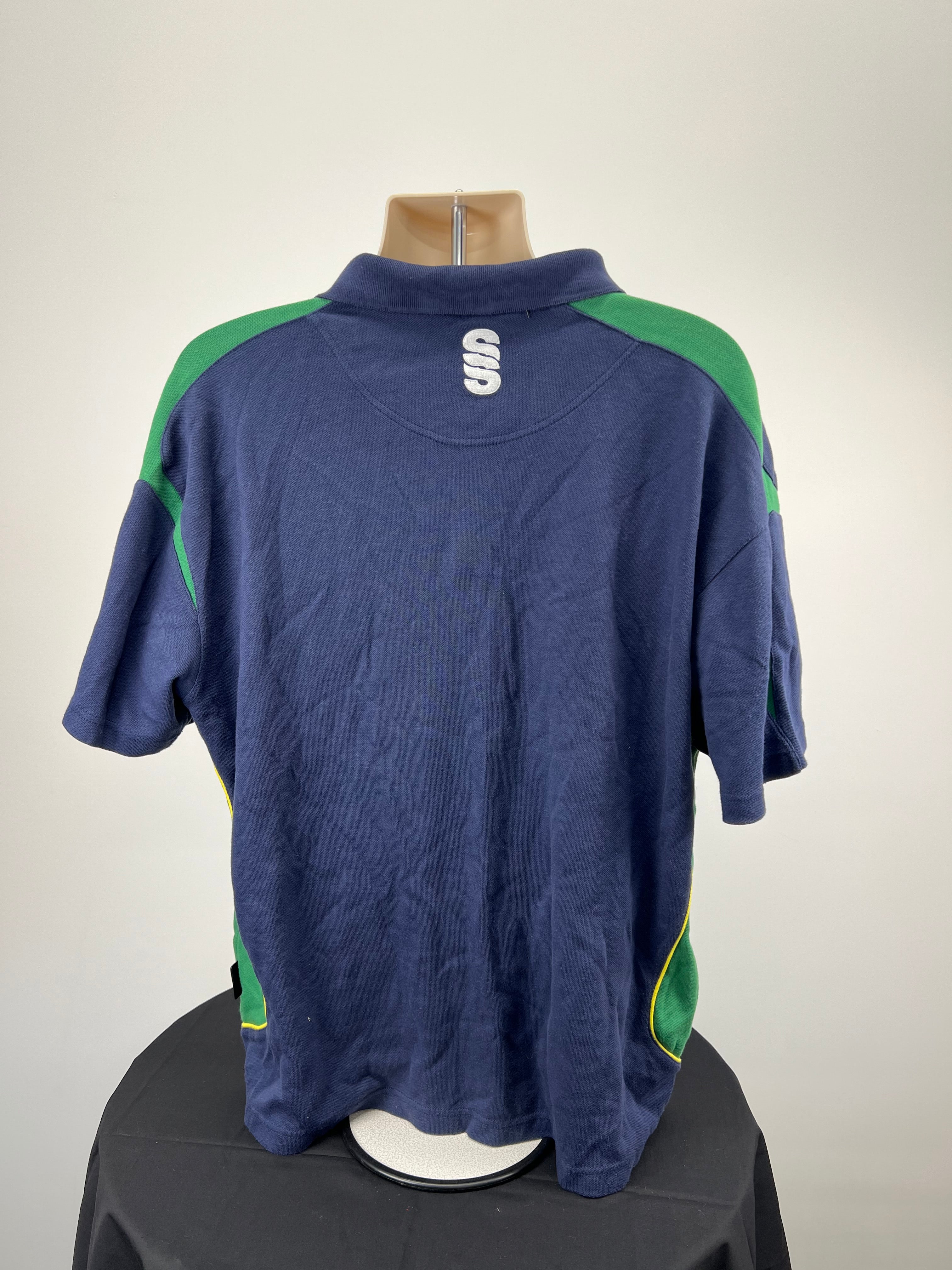 Back view of navy Northants cricket polo showing green accents and Suridge logo on the collar