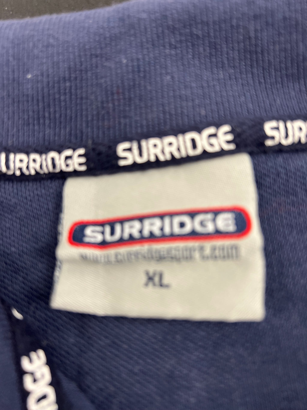 Close-up of Suridge brand label inside the neck of Northants cricket polo shirt size XL