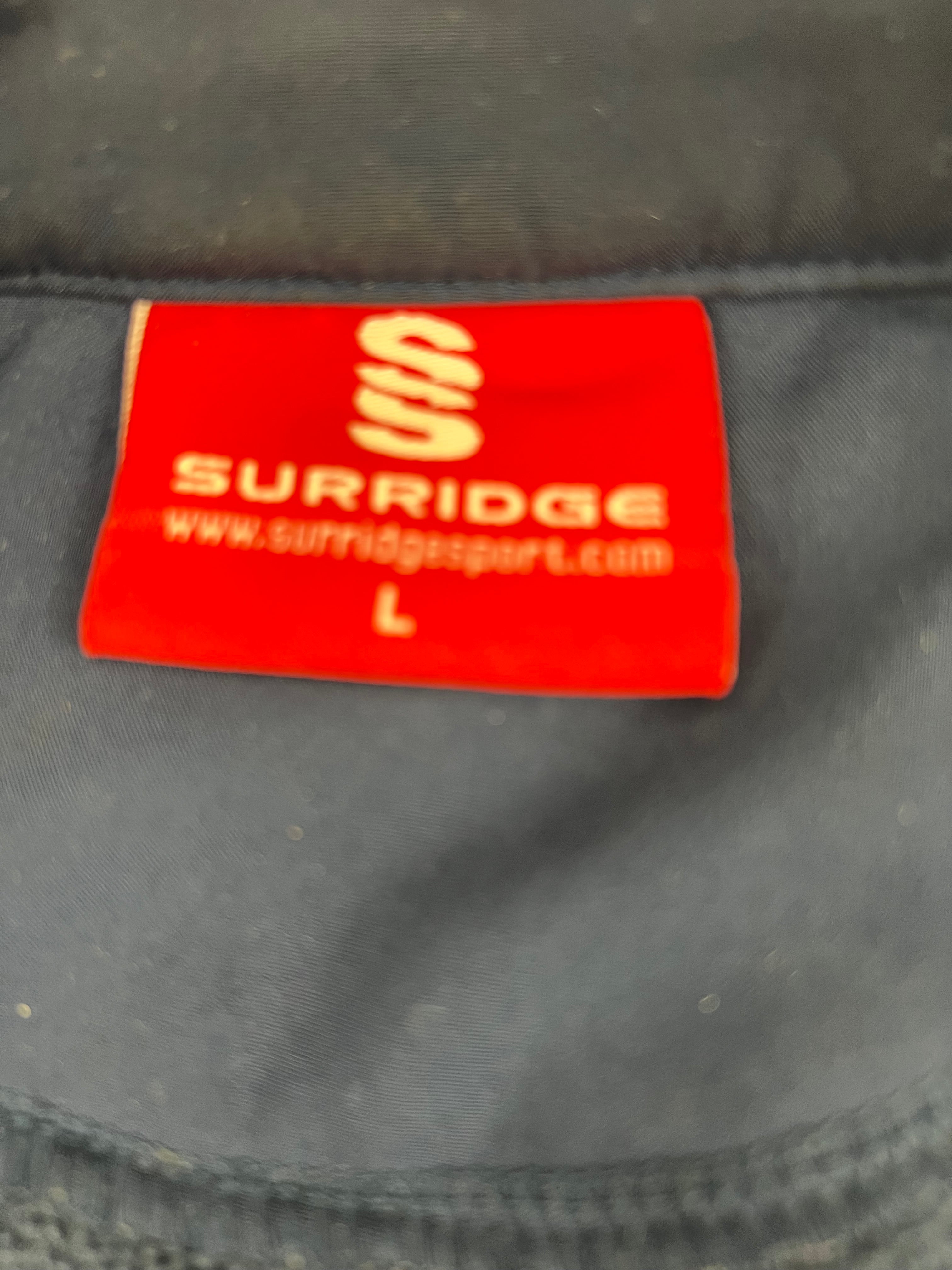 Close-up of red Surridge brand label showing size L inside cricket gilet