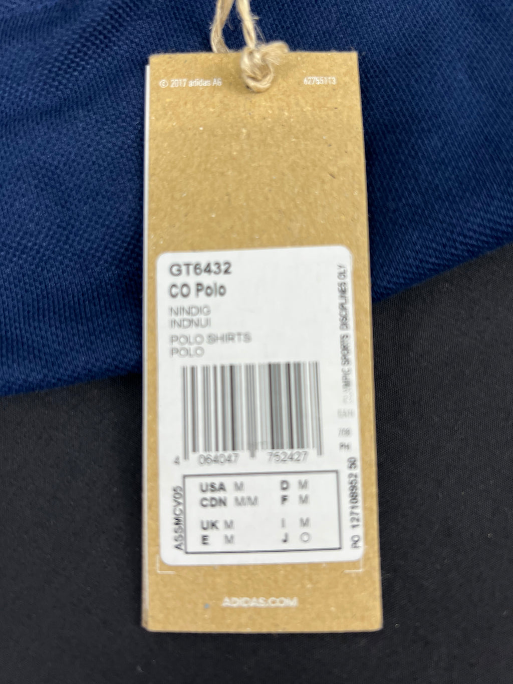 Close-up of Adidas product tag showing size and model details of Team GB polo shirt