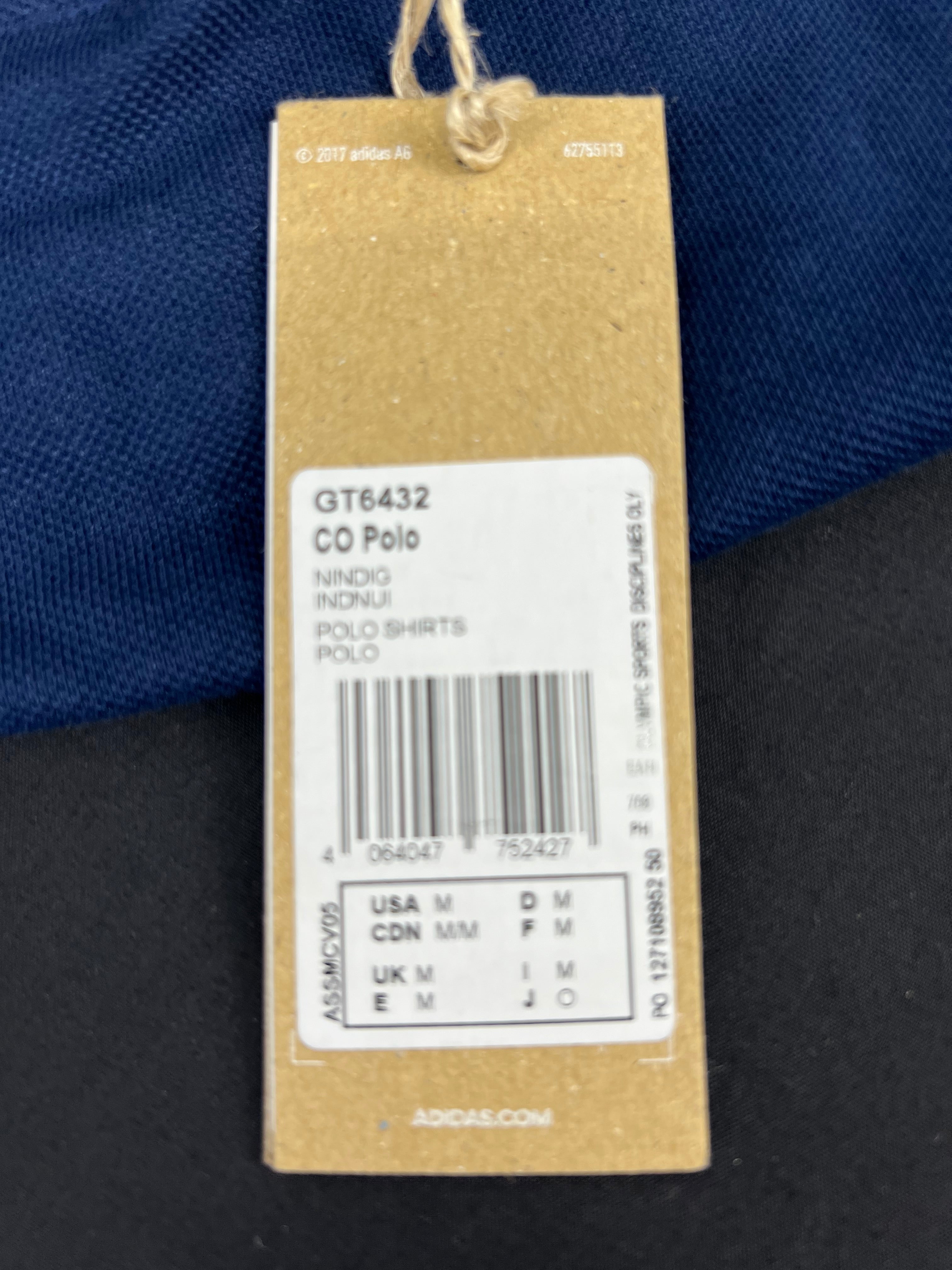 Close-up of Adidas product tag showing size and model details of Team GB polo shirt
