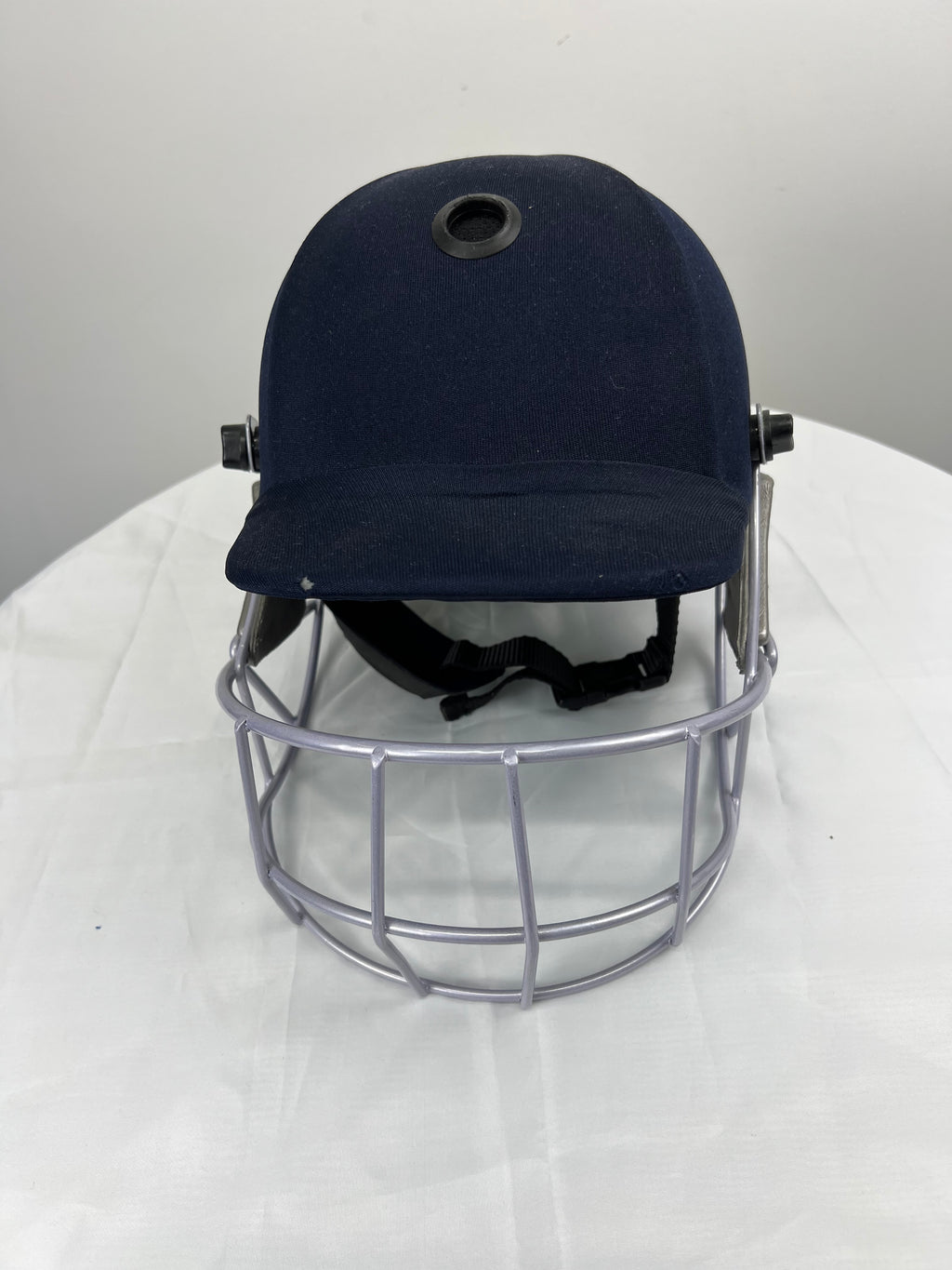 Front view of navy blue Kookaburra youth cricket helmet with silver face grill