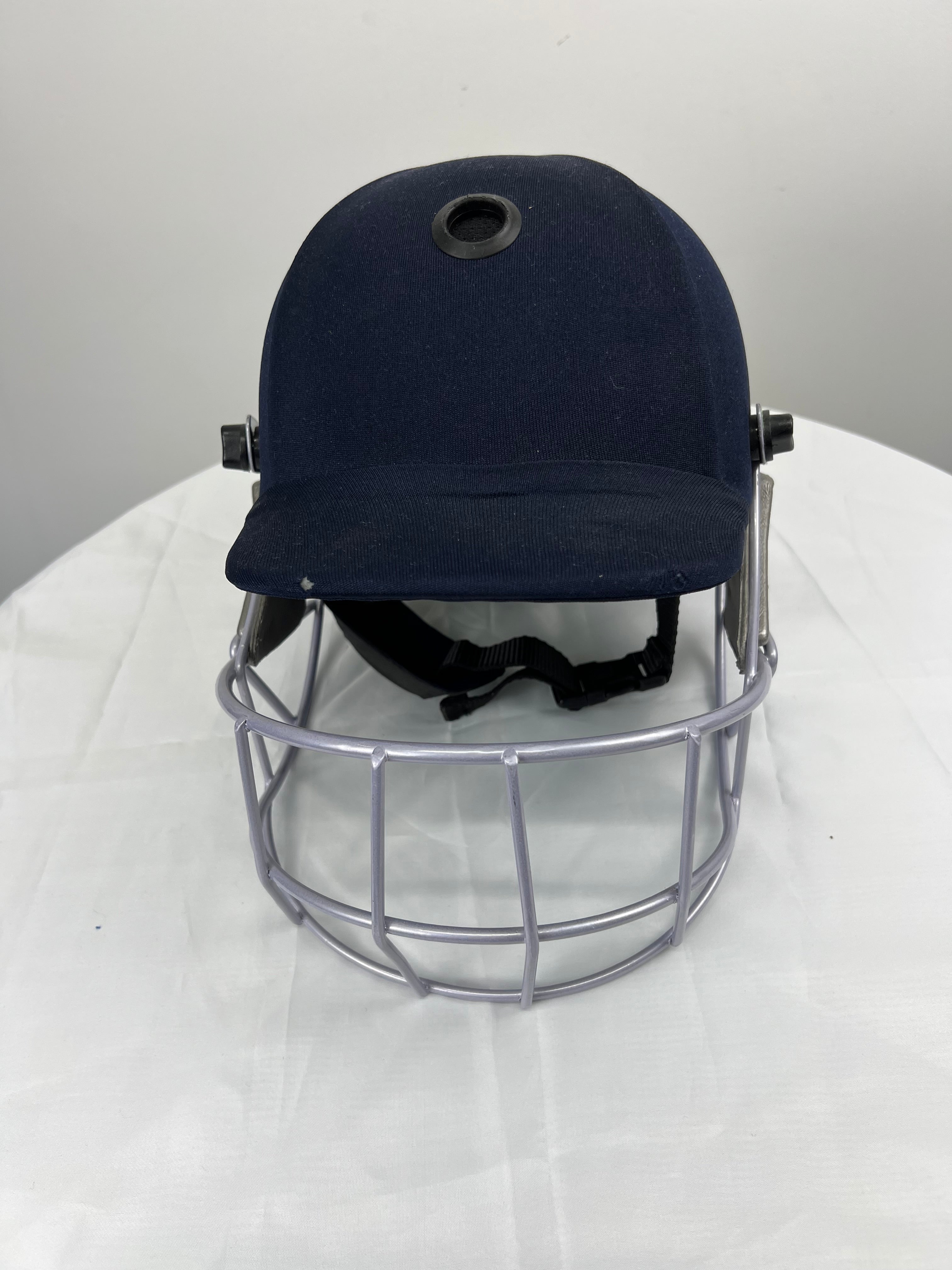 Front view of navy blue Kookaburra youth cricket helmet with silver face grill