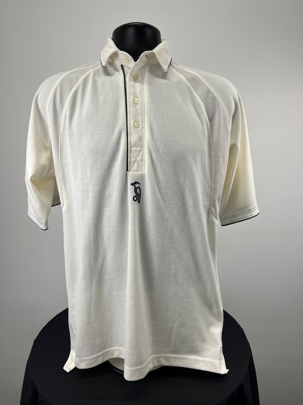 Front view of Kookaburra cricket polo shirt in white with navy piping on collar and sleeves