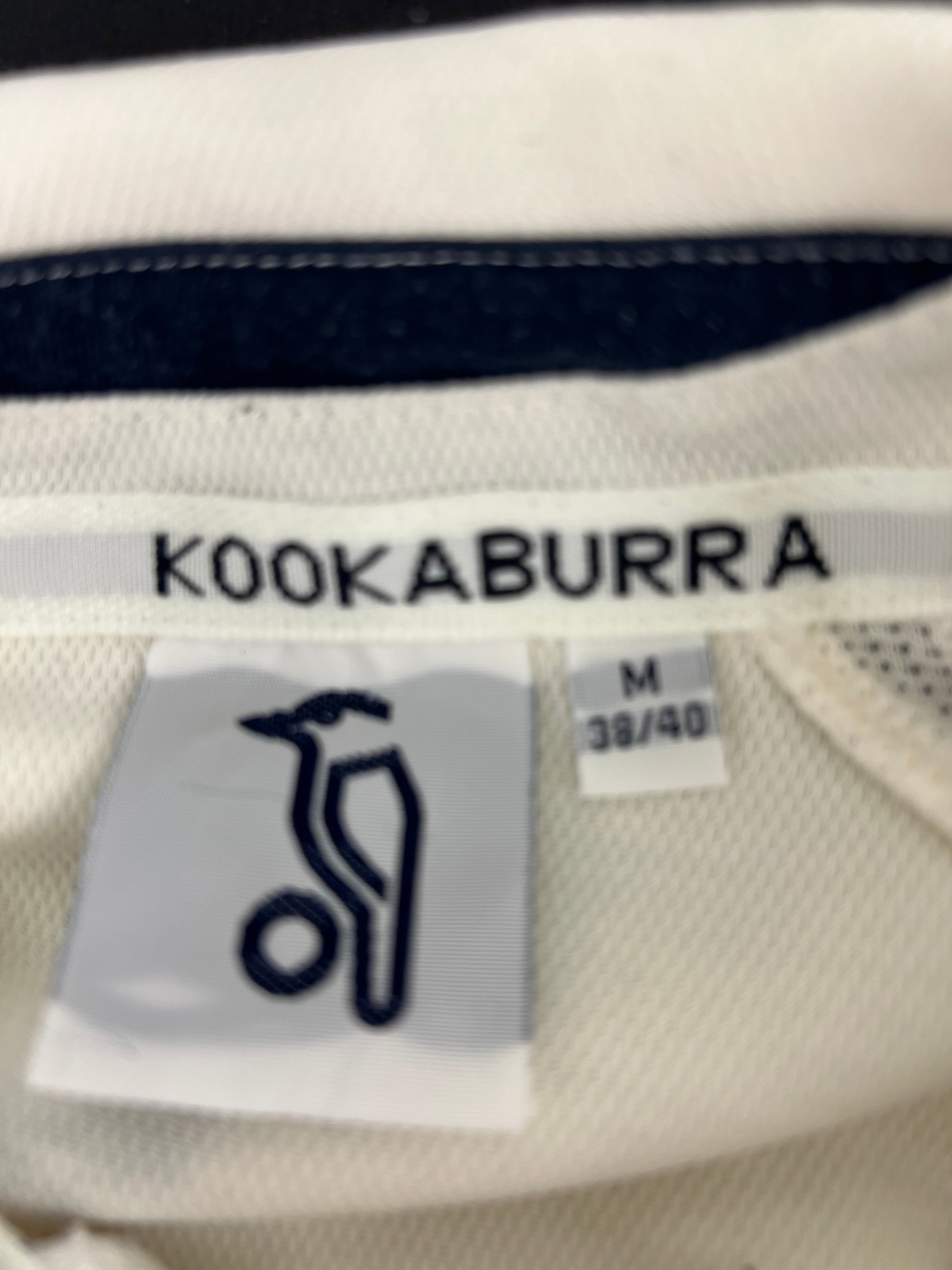 Close-up shot of Kookaburra label and size M tag inside the cricket polo collar