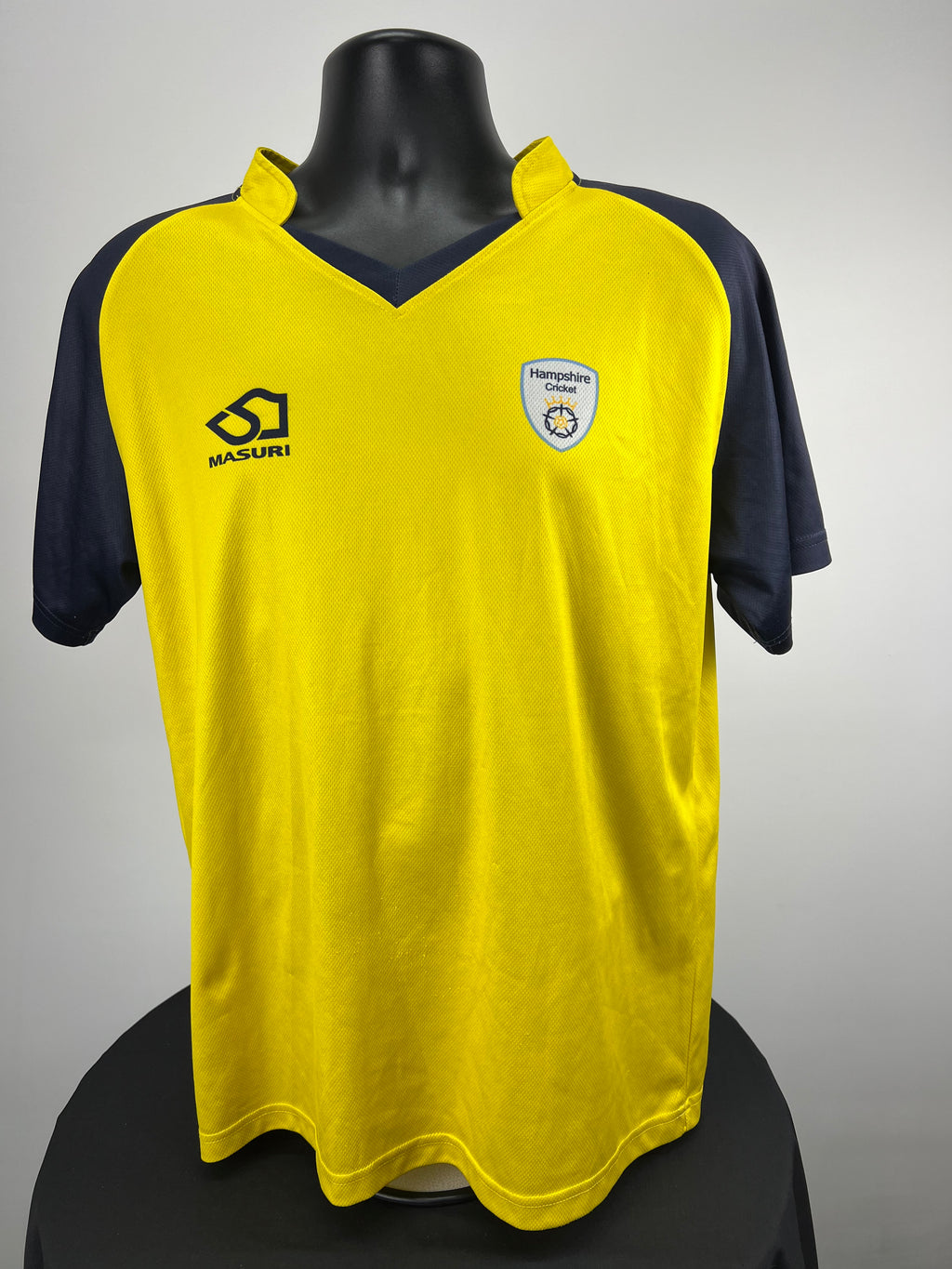 Front view of Hampshire Cricket yellow and navy sleeve top on mannequin