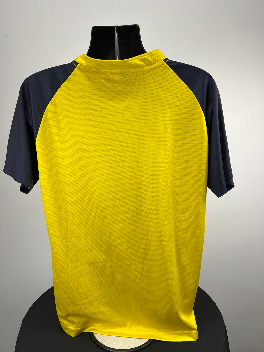 Back view of Hampshire Cricket yellow and navy sleeve top showing solid colour and raglan sleeve design