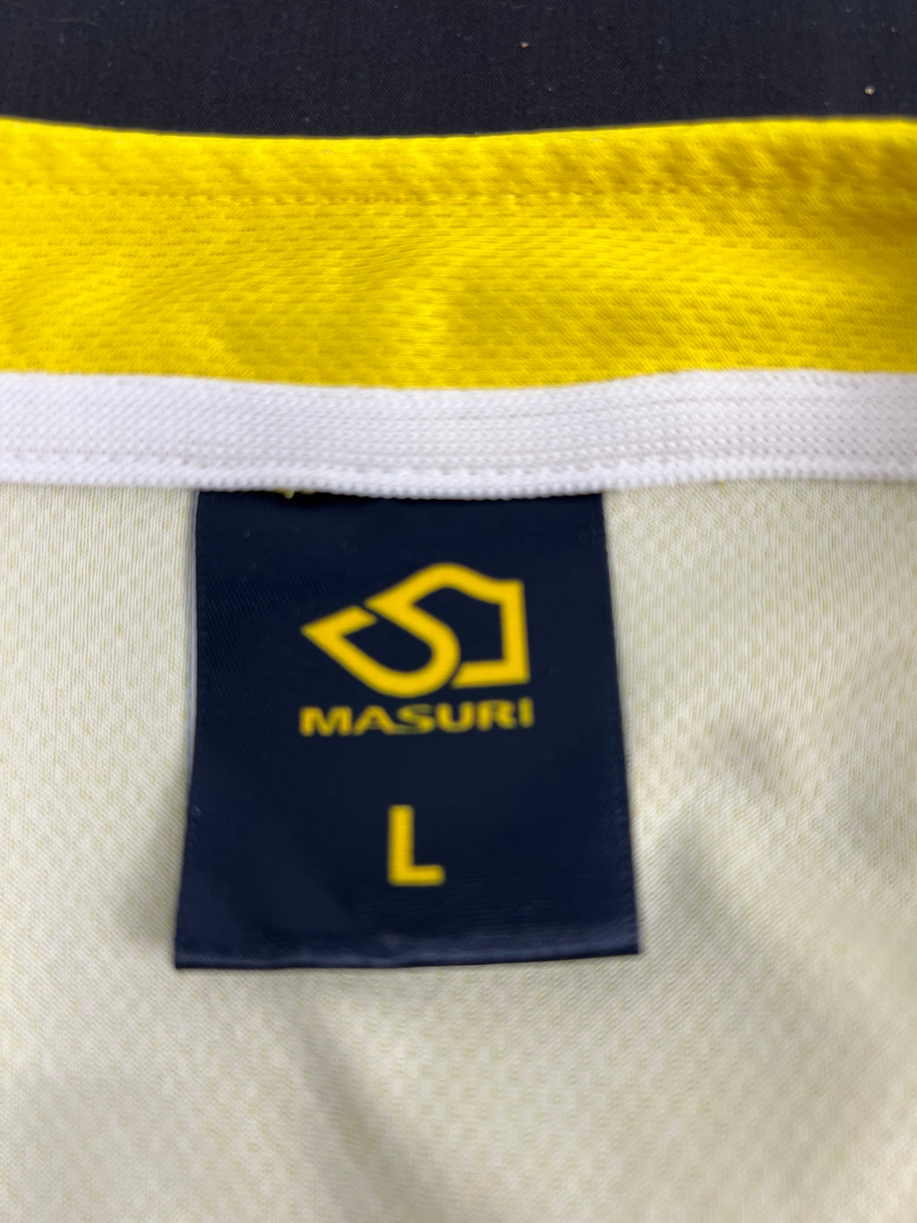 Close-up of Masuri brand label with size L inside Hampshire Cricket sleeve top