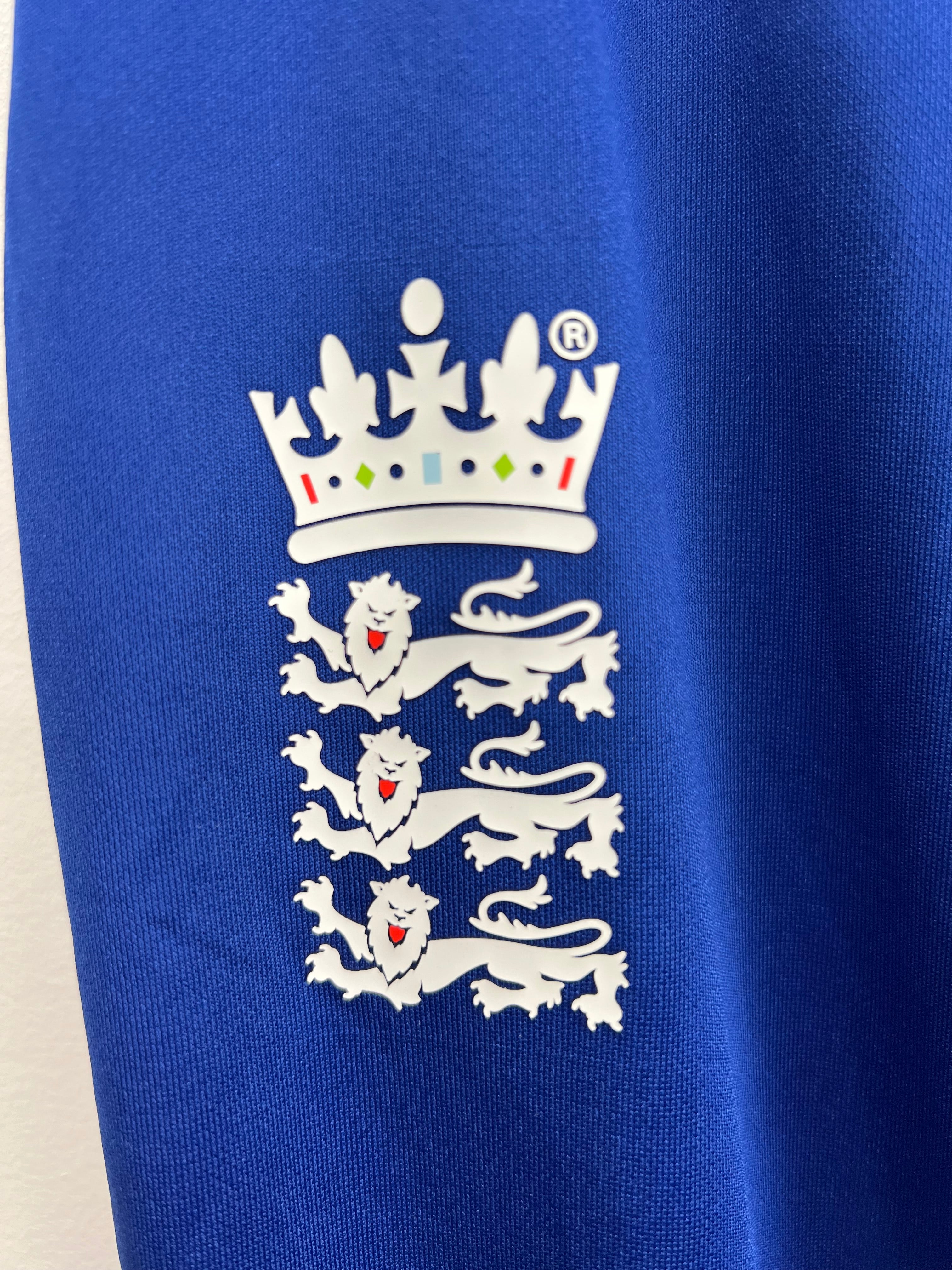 Close-up of the England Lions emblem on the royal blue Castore cricket tracksuit bottoms