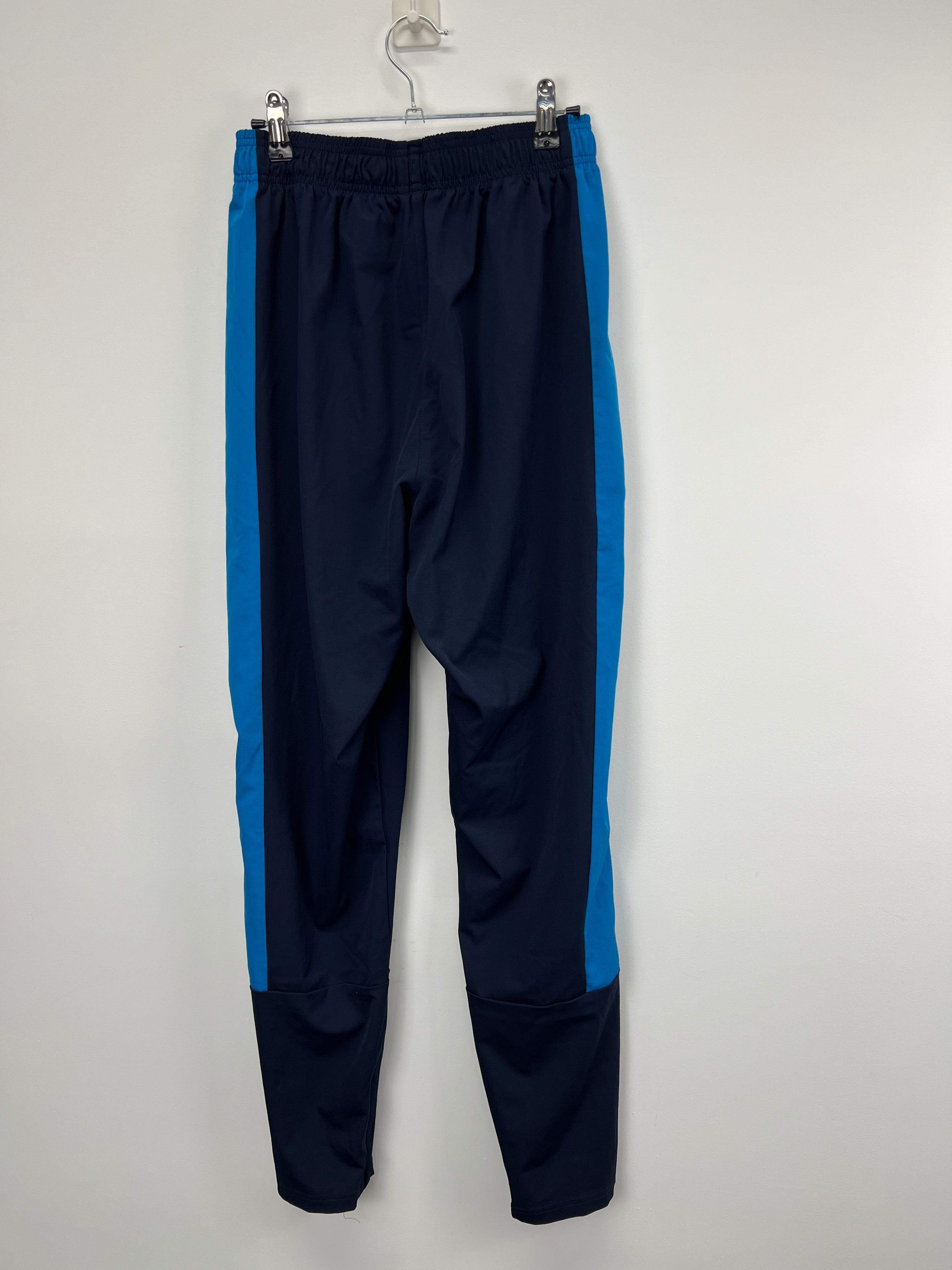 Back view of Men’s New Balance cricket tracksuit trousers showing elasticated waistband and blue side stripes