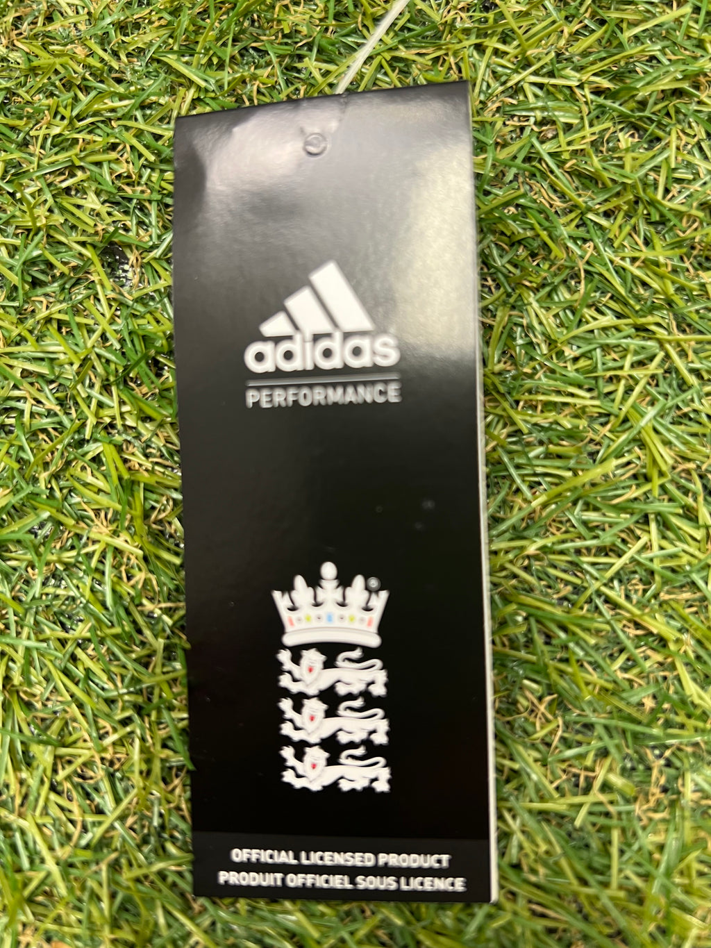 Close-up of adidas performance tag with ECB branding attached to tracksuit bottoms