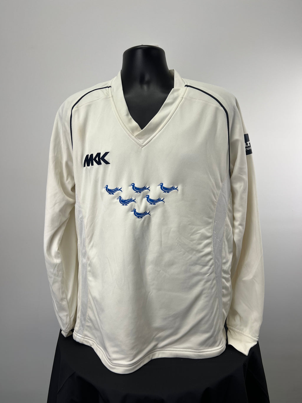 Front view of Monty Panesar cream long sleeve cricket jumper with Sussex logo and MKK branding