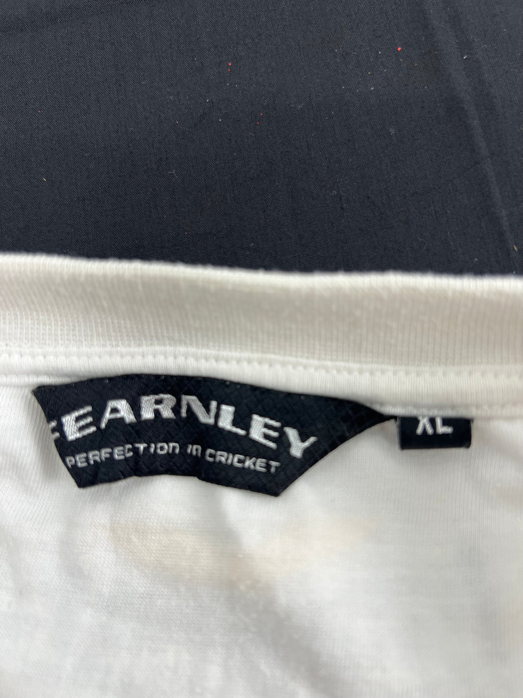 Close-up of Earnley brand label inside white cricket t-shirt