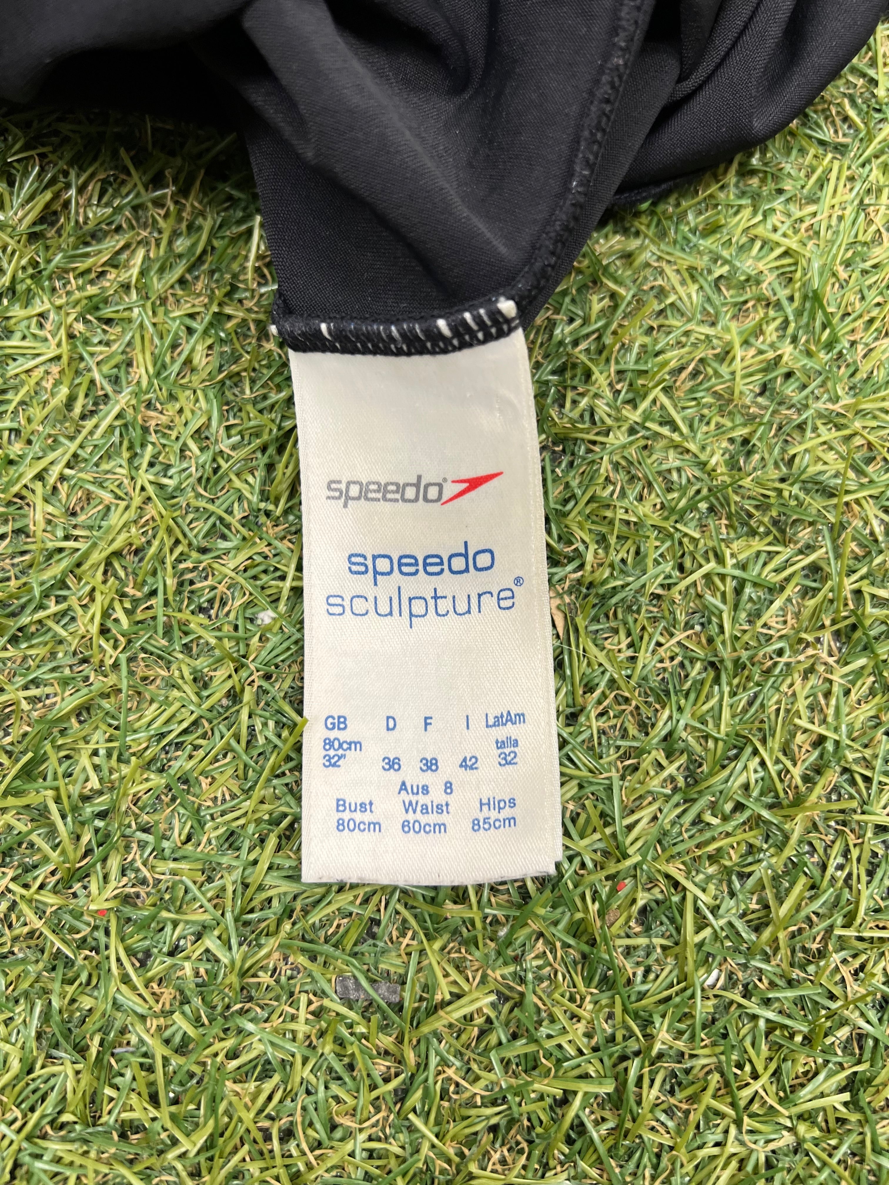 Close-up of Speedo Sculpture label inside black swimsuit indicating size 32 inches and care details