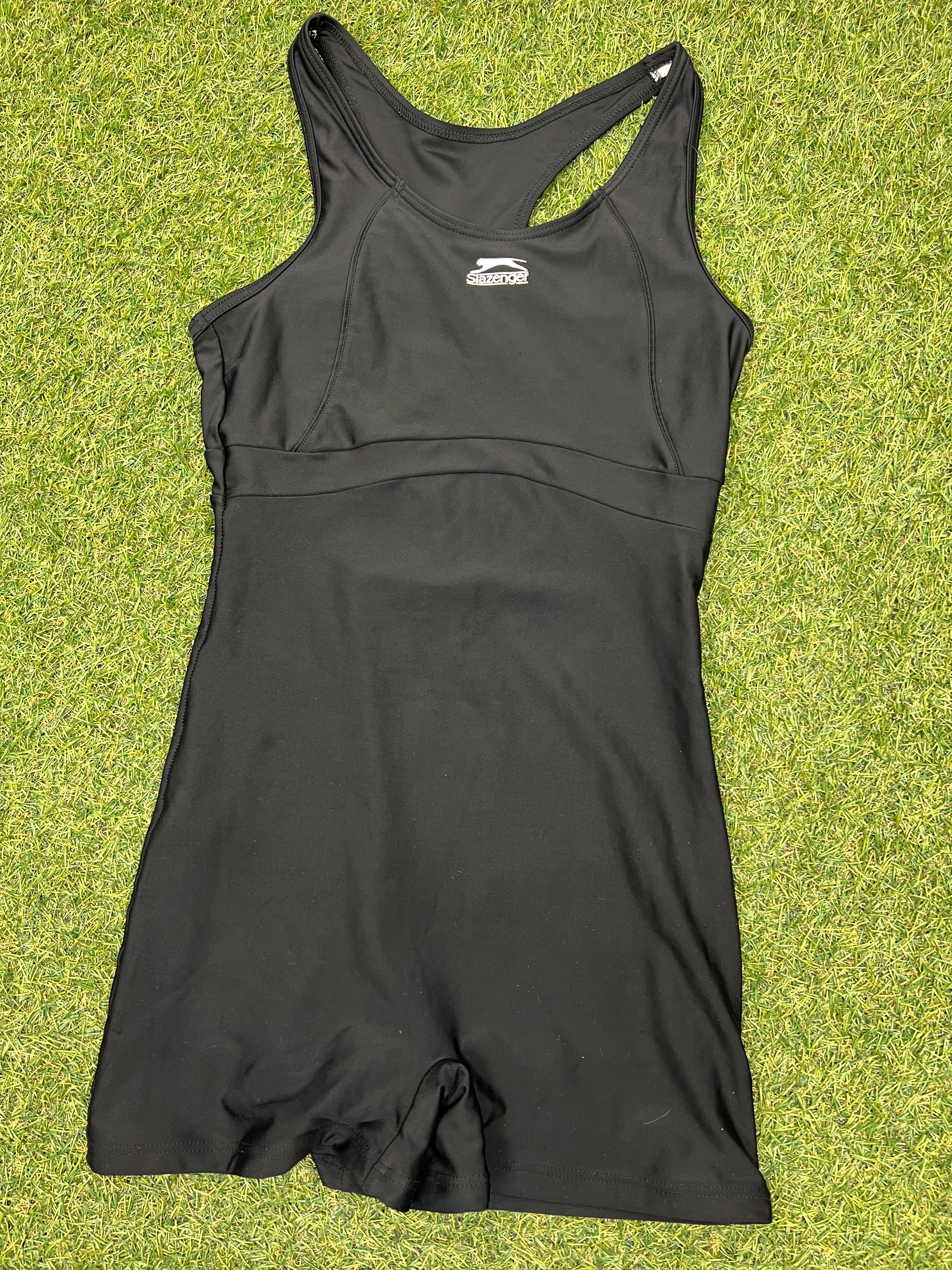 Front view of black Slazenger swimsuit size 10 lying flat on grass
