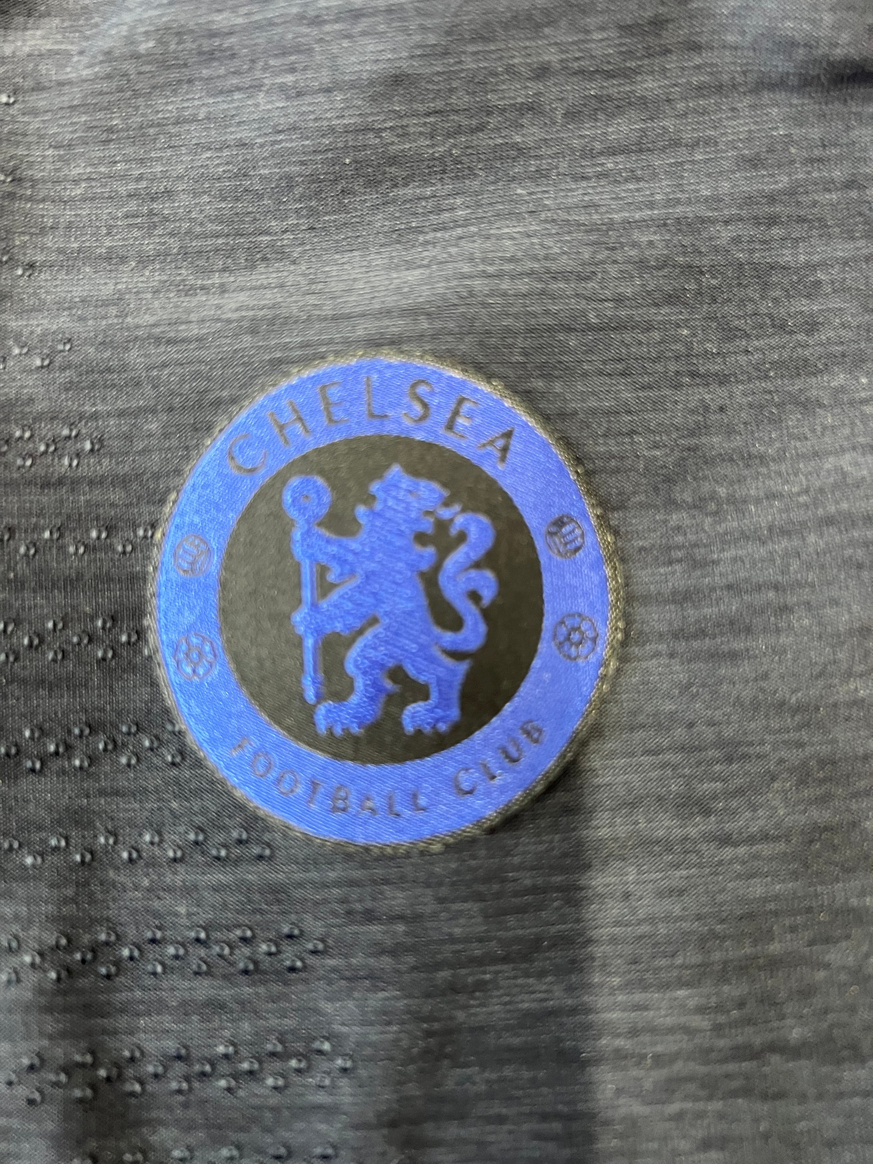 Close-up of Nike swoosh and Chelsea FC blue crest on the front of Nike VaporKnit training top