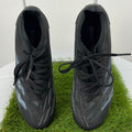 Pair of black Adidas Predator football boots viewed from above on artificial grass