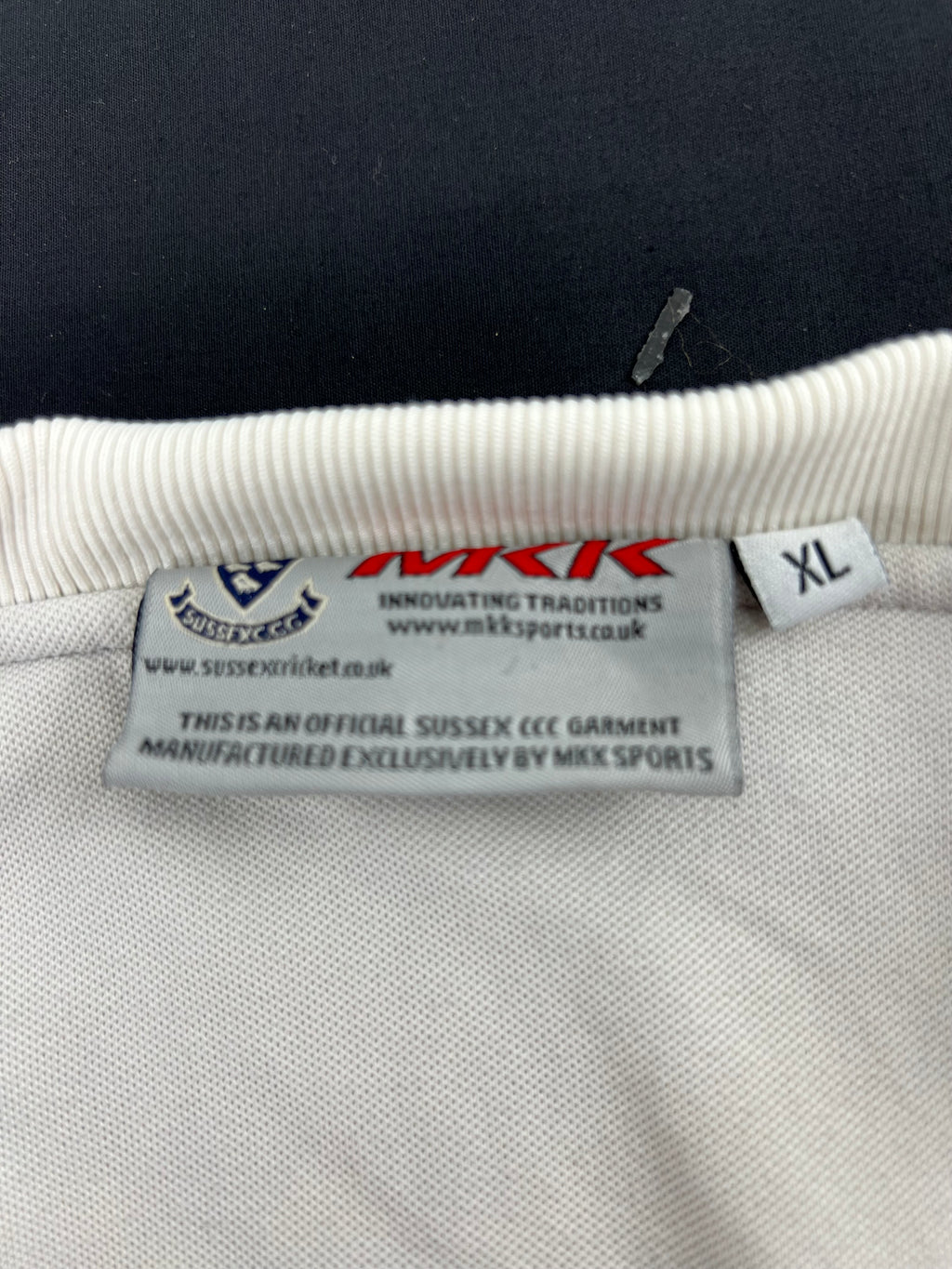 Tag inside jumper displaying MKK Sports branding, Sussex CCC logo, and XL size designation