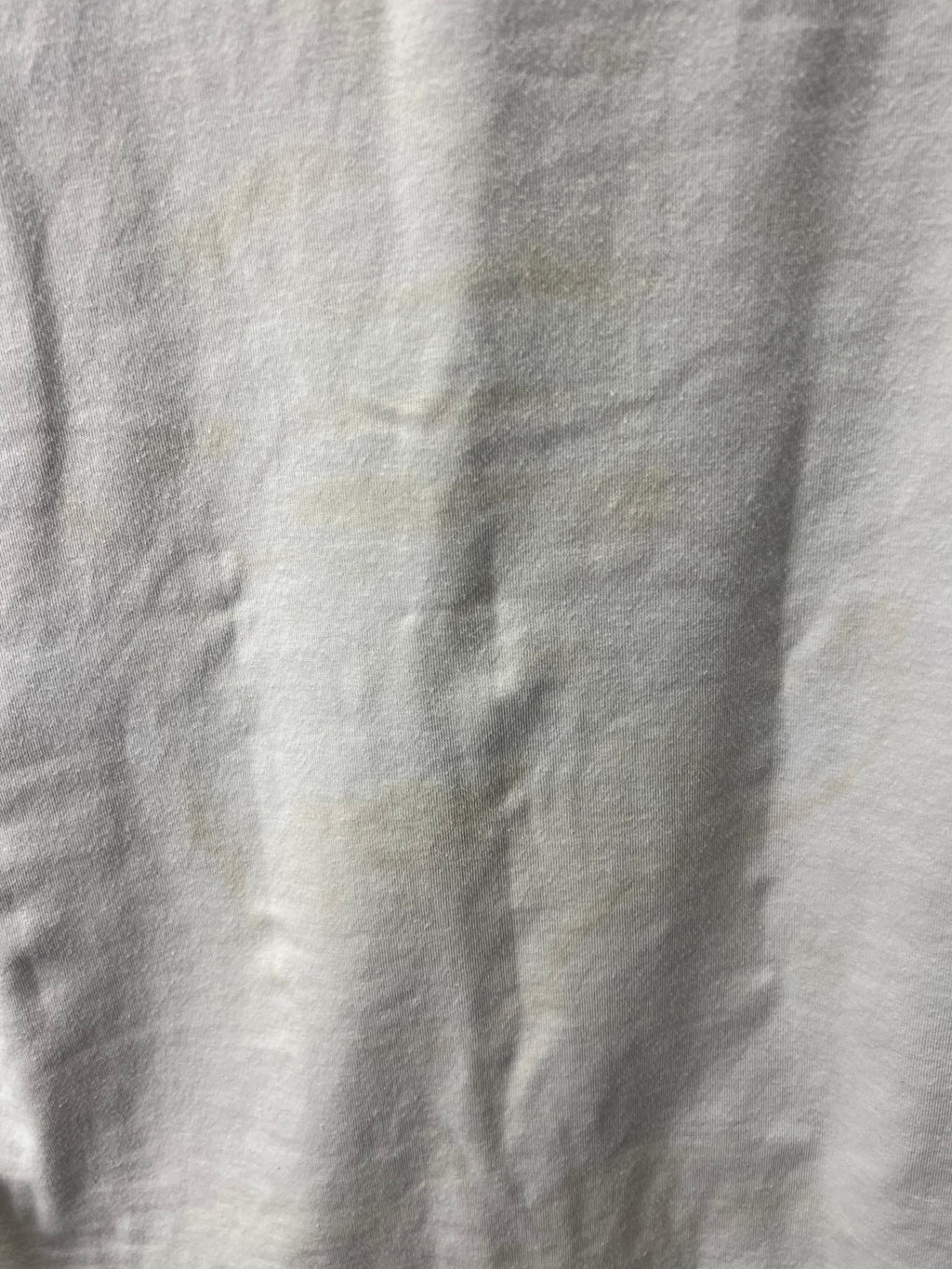 Close-up of light discoloration marks on the back of the cricket polo