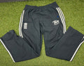 Men's England cricket tracksuit trousers laid flat on grass, black with white stripes and logos