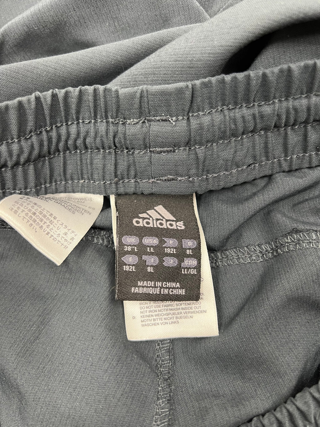Label inside tracksuit trousers showing adidas branding and size 38L information