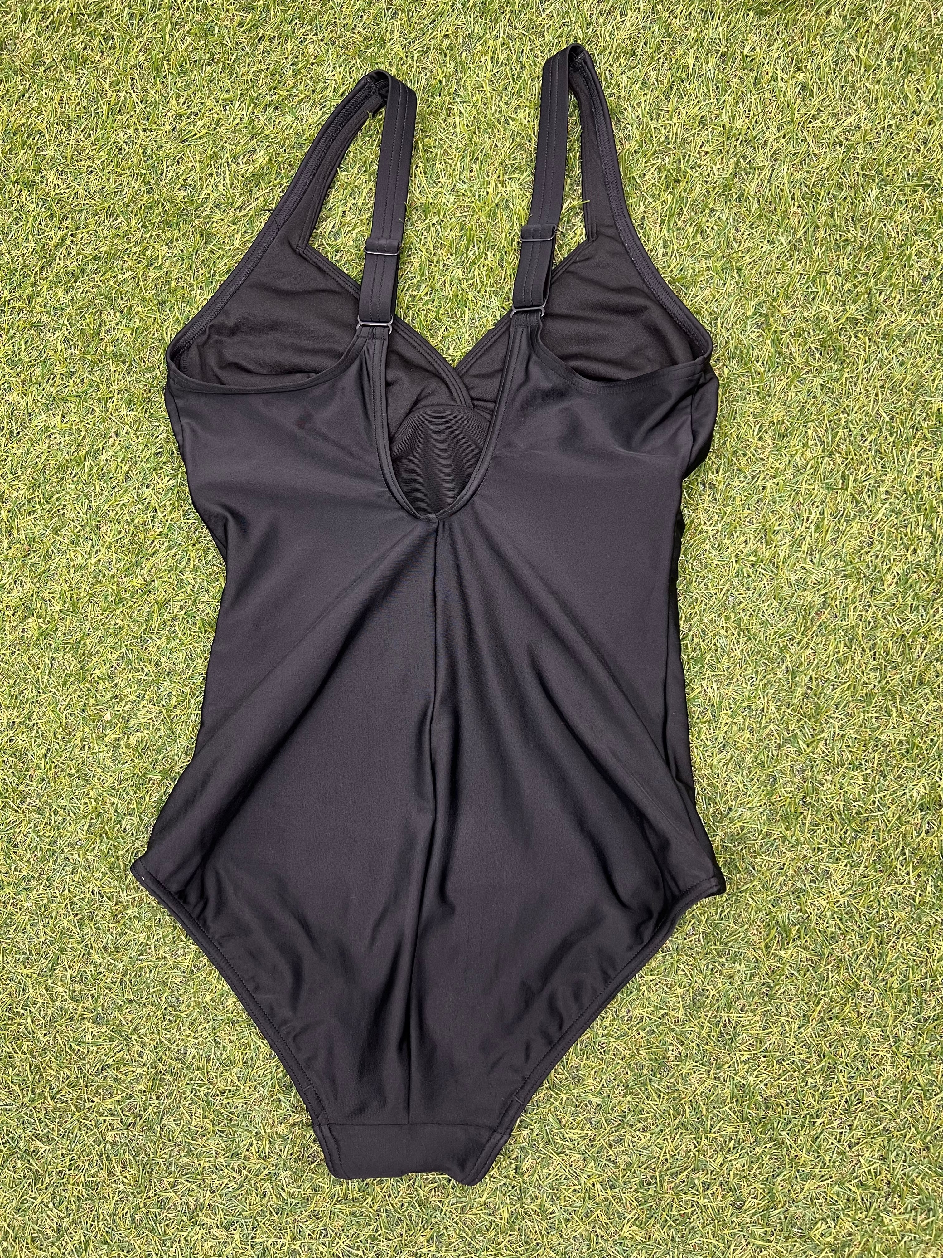 Back view of black Speedo swimsuit with adjustable shoulder straps on grass