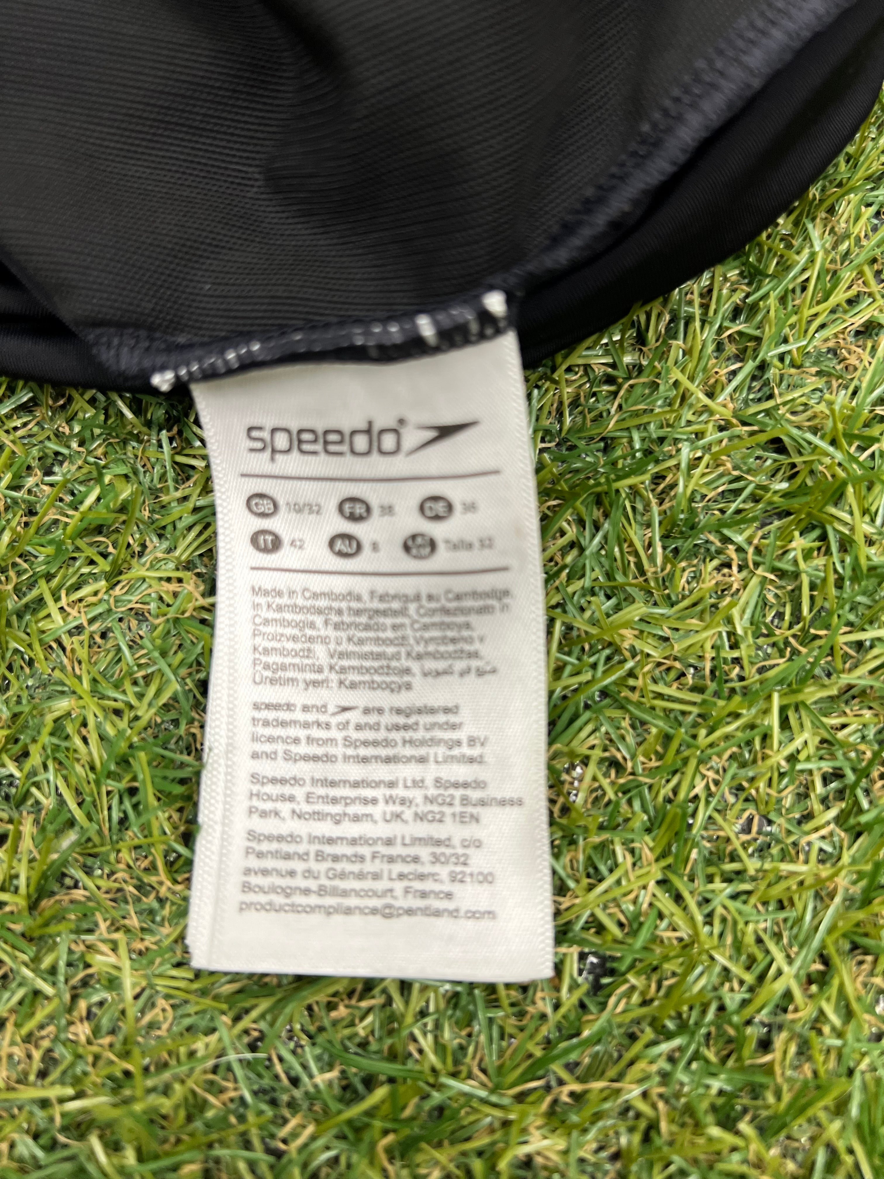 Close-up of Speedo swimsuit size and care label on grass