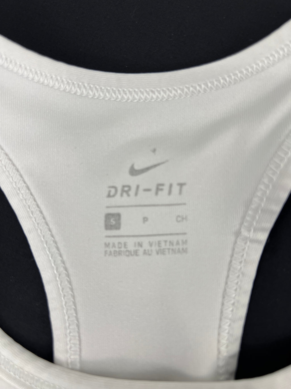 Close-up of Nike label inside sports bra showing size small and Dri-FIT branding