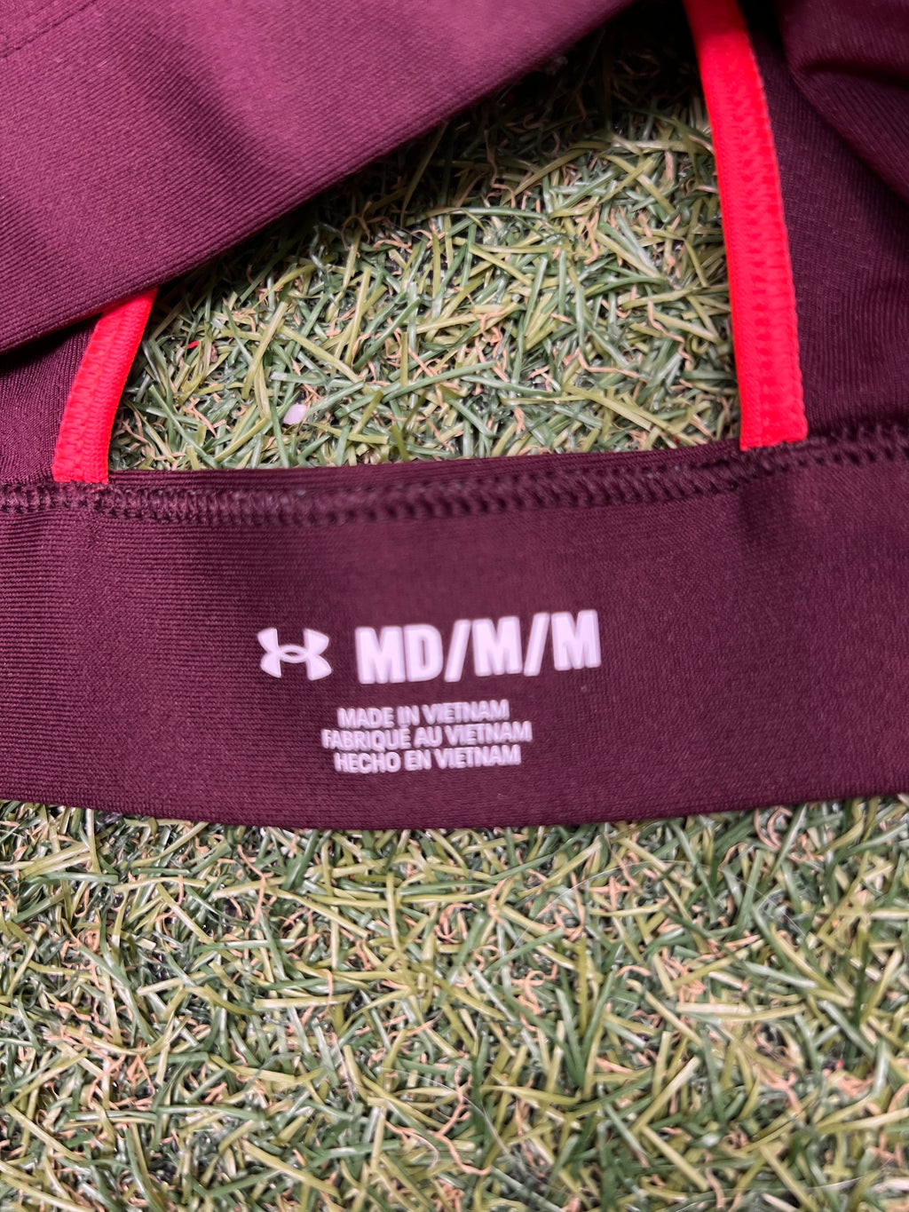 Close-up of size label inside Under Armour sports bra indicating medium size and made in Vietnam