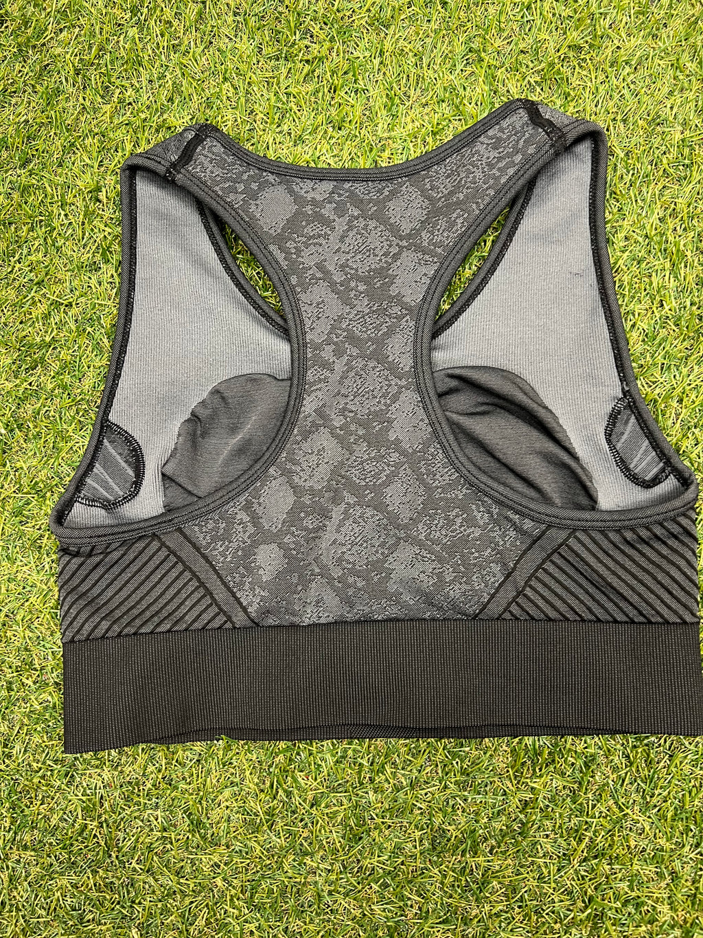 Back view of racerback USA Pro sports bra showing inner lining and striped side panels