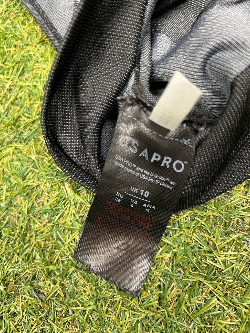 Close-up of USA Pro black care label inside sports bra with size UK 10 details