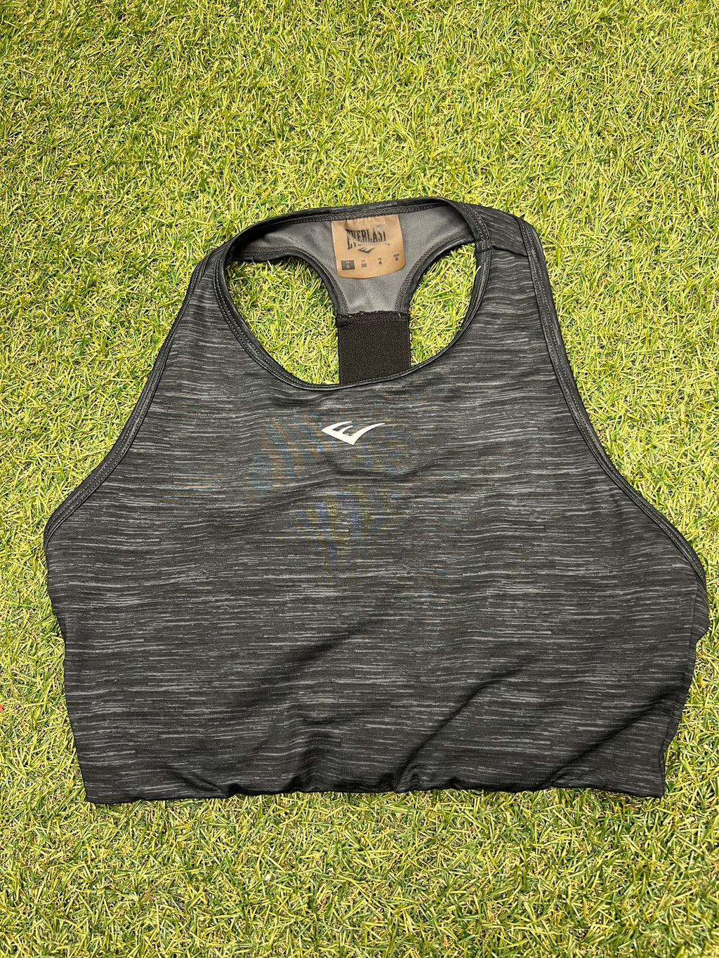 Front view of black Everlast sports bra top with subtle heather pattern and Everlast logo
