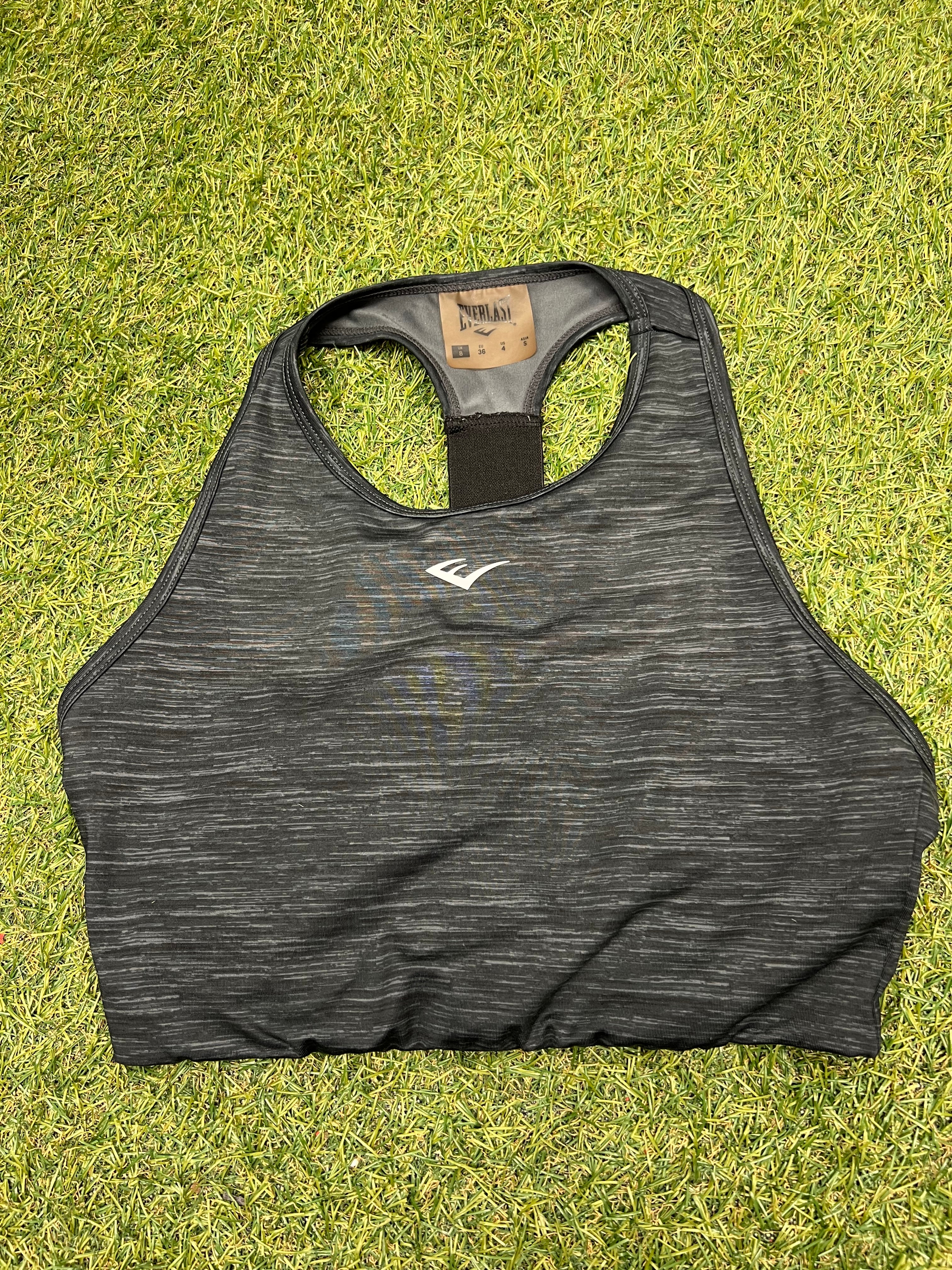 Front view of black Everlast sports bra top with subtle heather pattern and Everlast logo