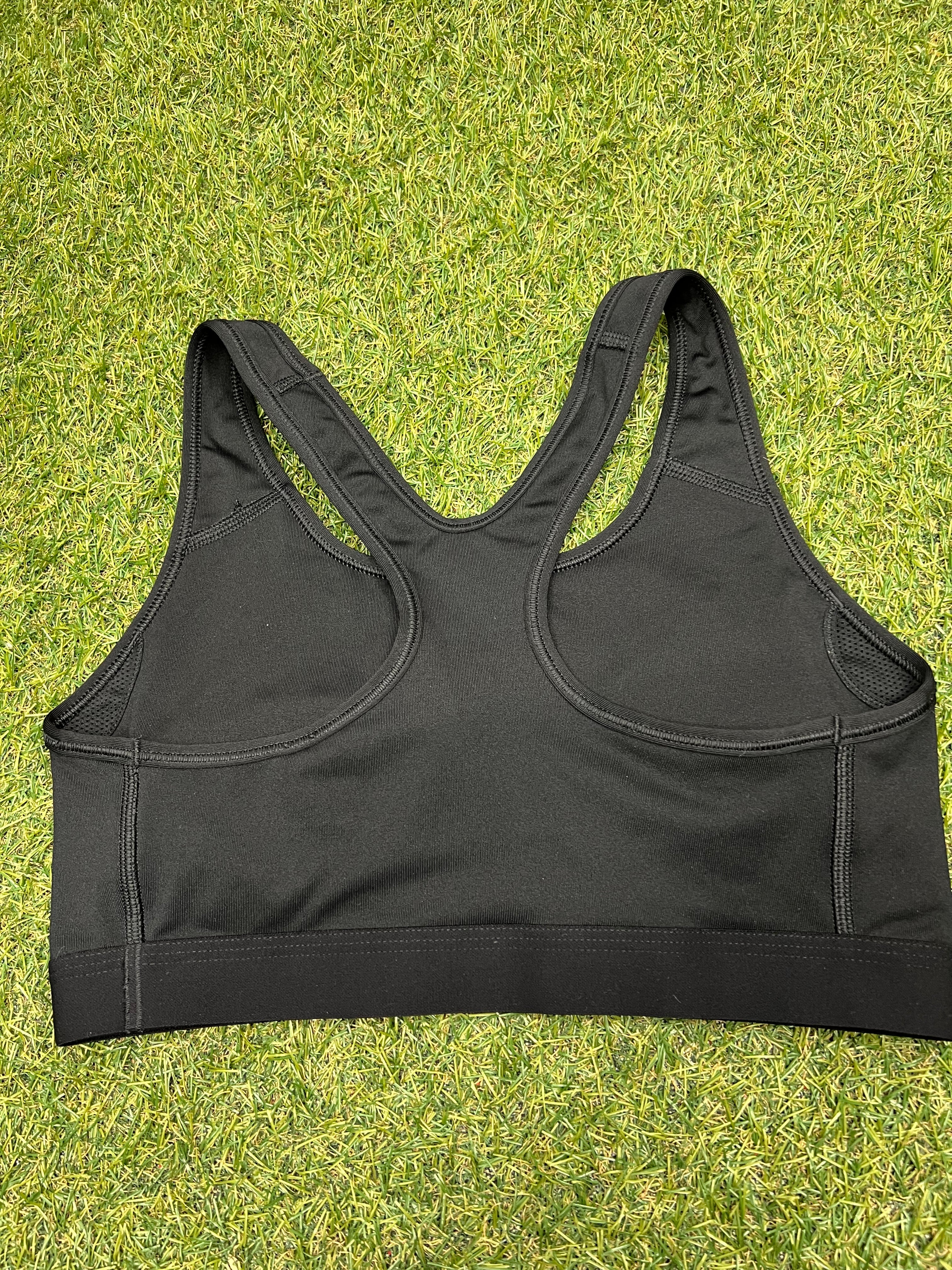 Back view of Nike black sports bra top showing racerback design and stitching details