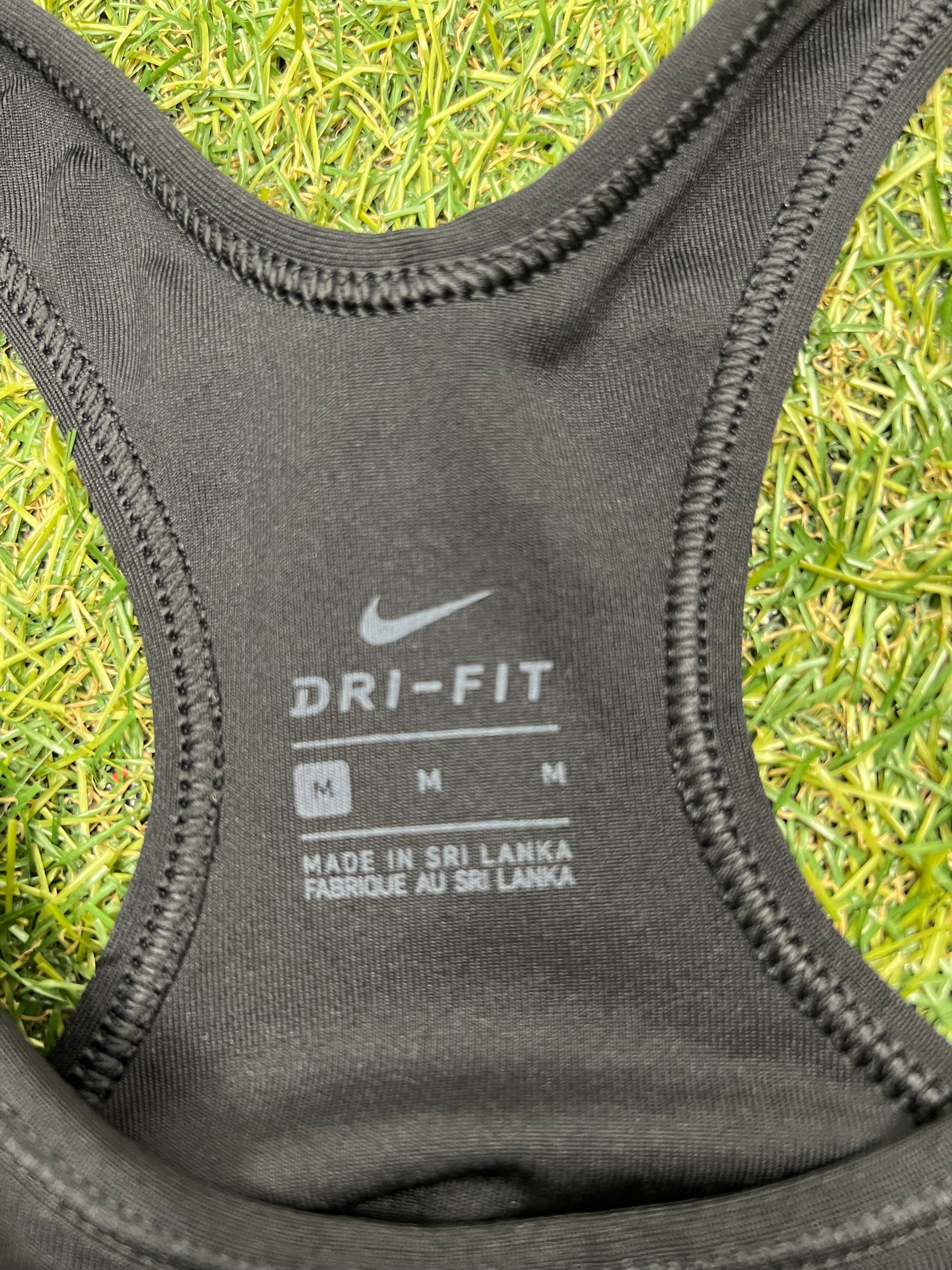 Close-up inside neck label of Nike Dri-FIT sports bra in size medium with manufacturing info