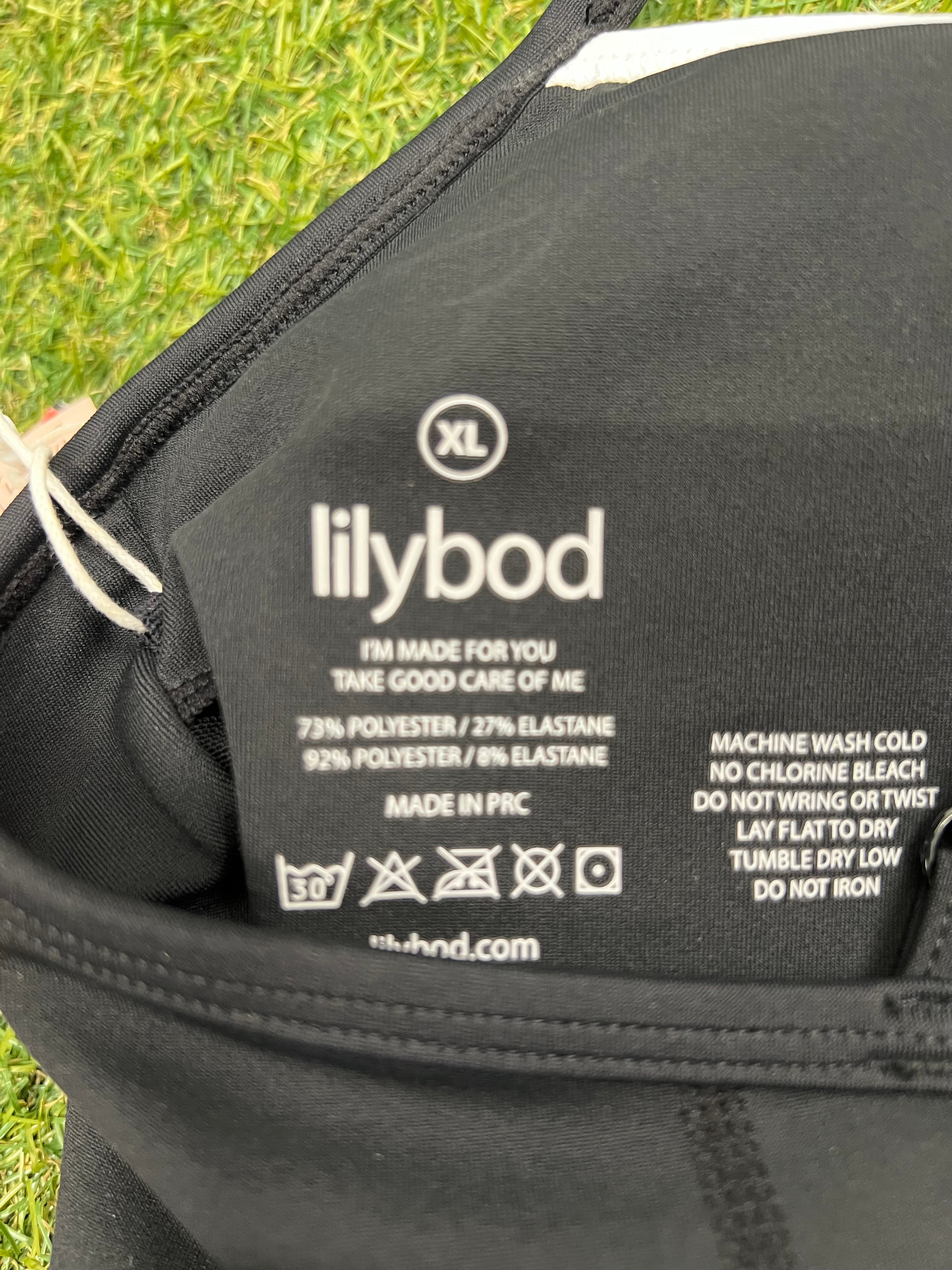 Close-up of Lilybod label and care instructions inside black sports bra top XL