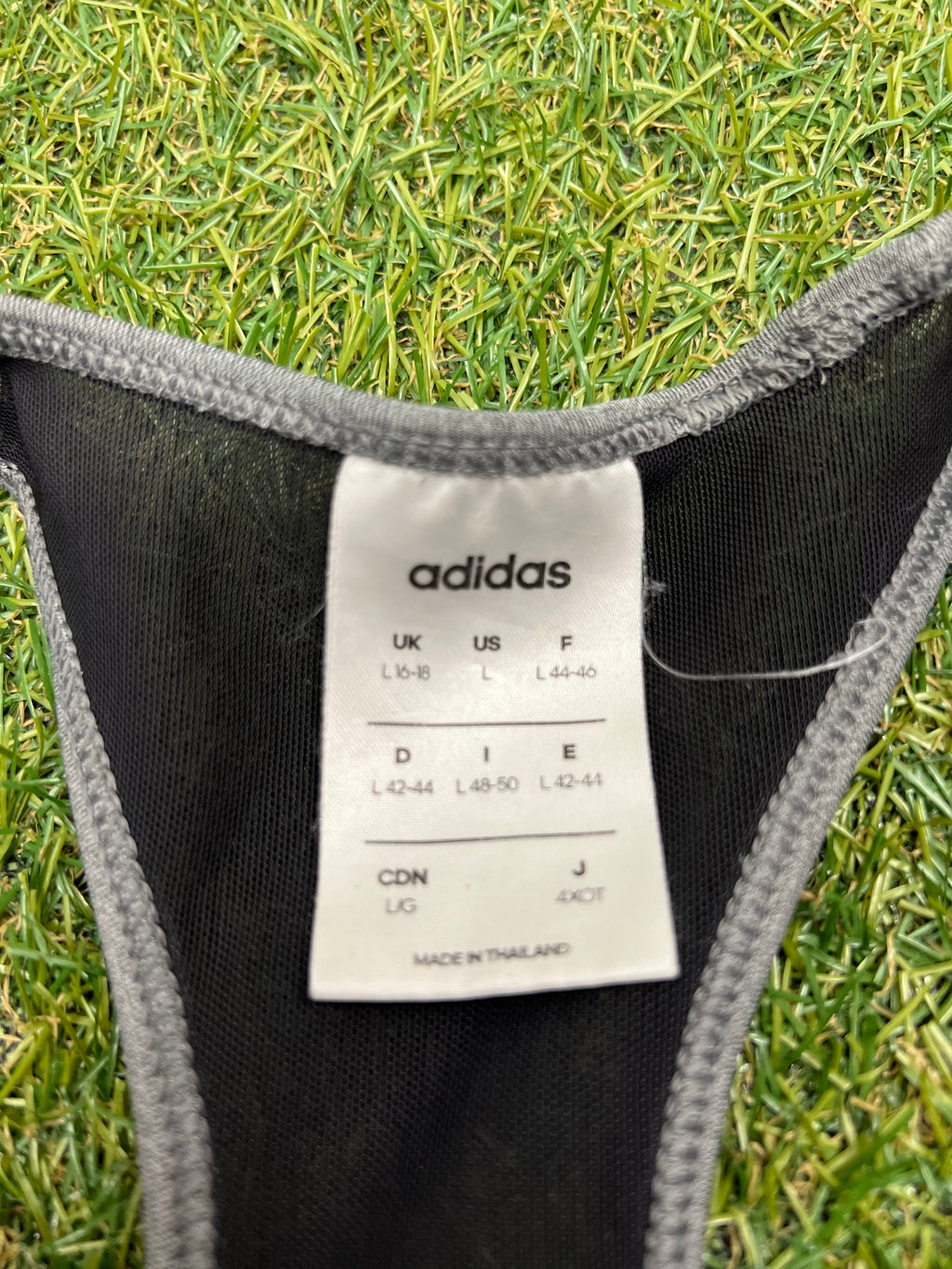 Close-up of size label inside Adidas sports bra top indicating size L 16-18