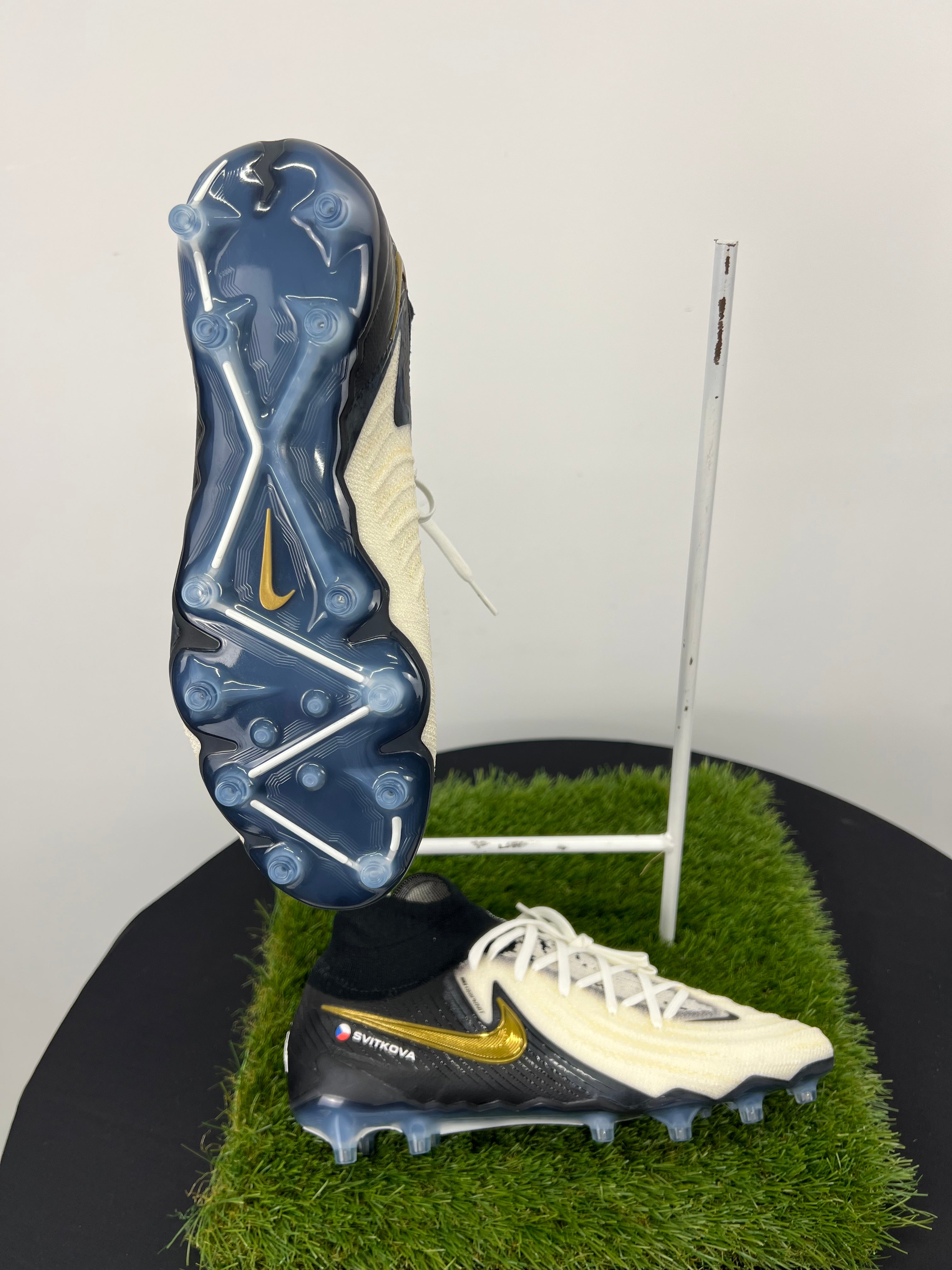 Side and bottom view showing cleats and Nike gold swoosh on football boots