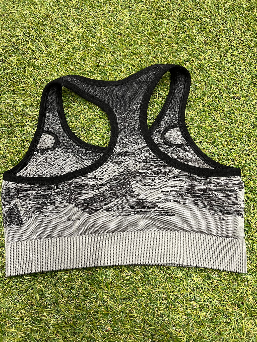 Back view showing the racerback design of Gymshark seamless sports bra top in black and grey