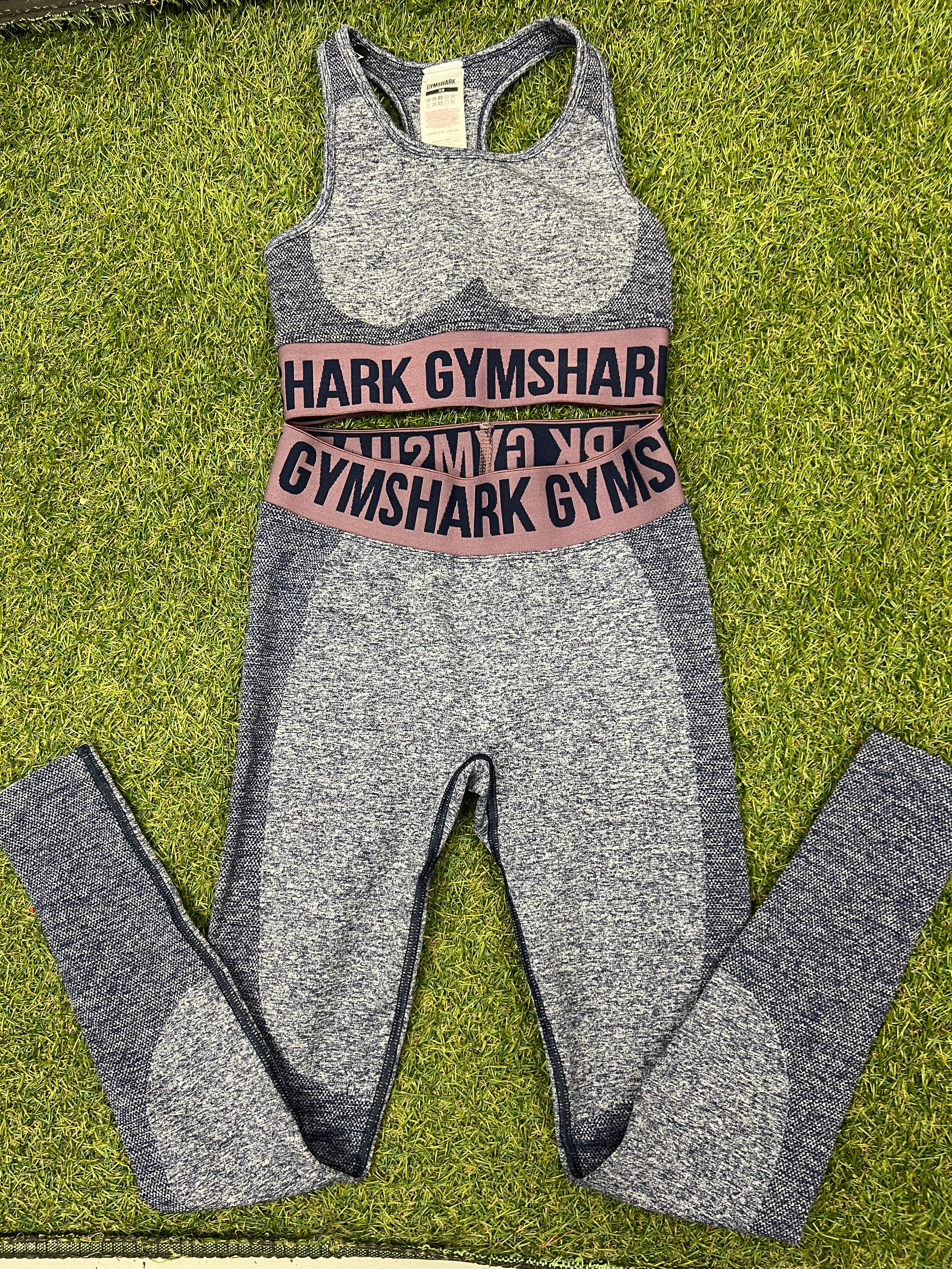 Front view of Gymshark blue marl bra top and leggings set laid flat on grass