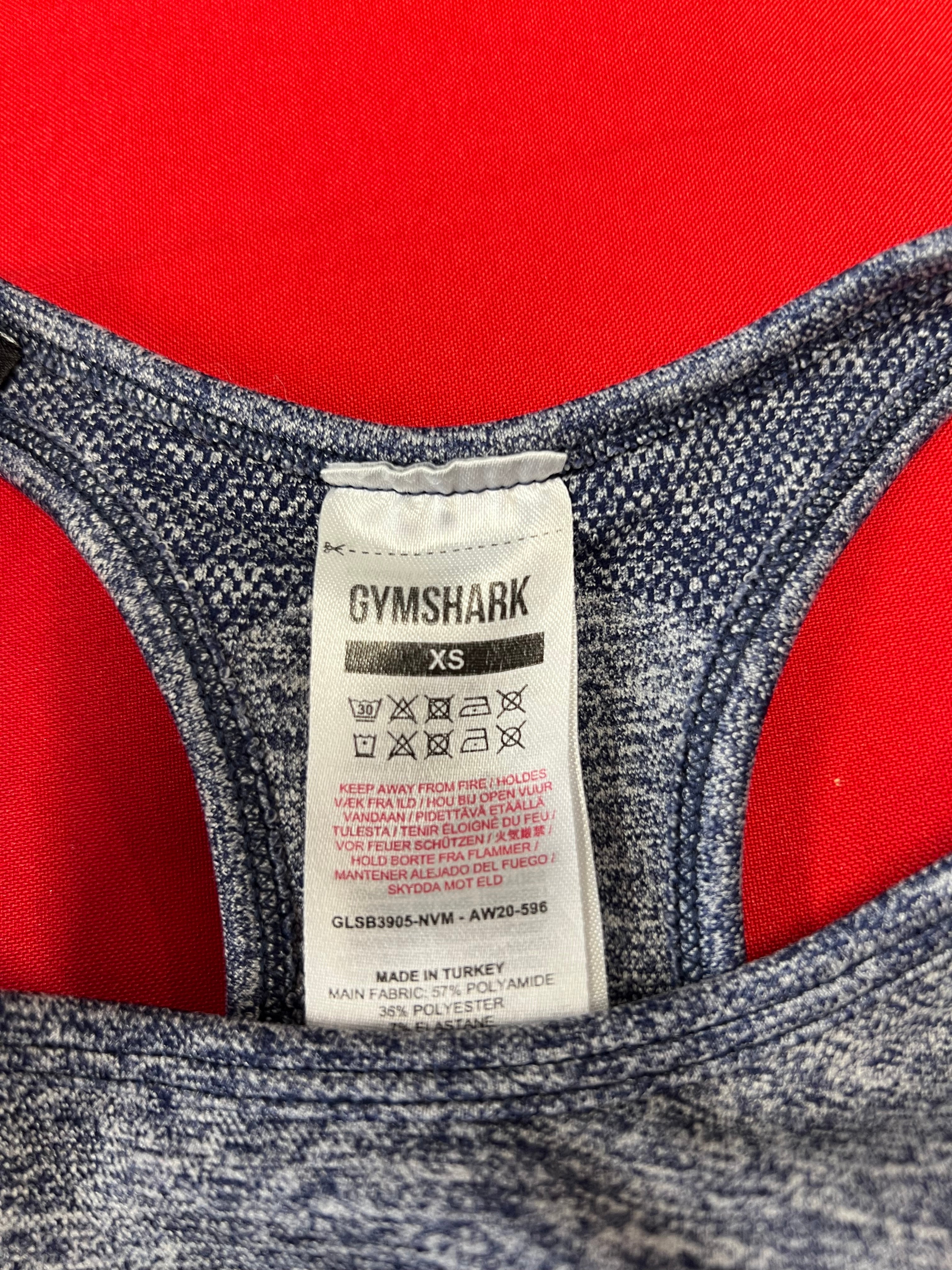 Close-up image of Gymshark XS size and fabric care label inside blue marl bra top