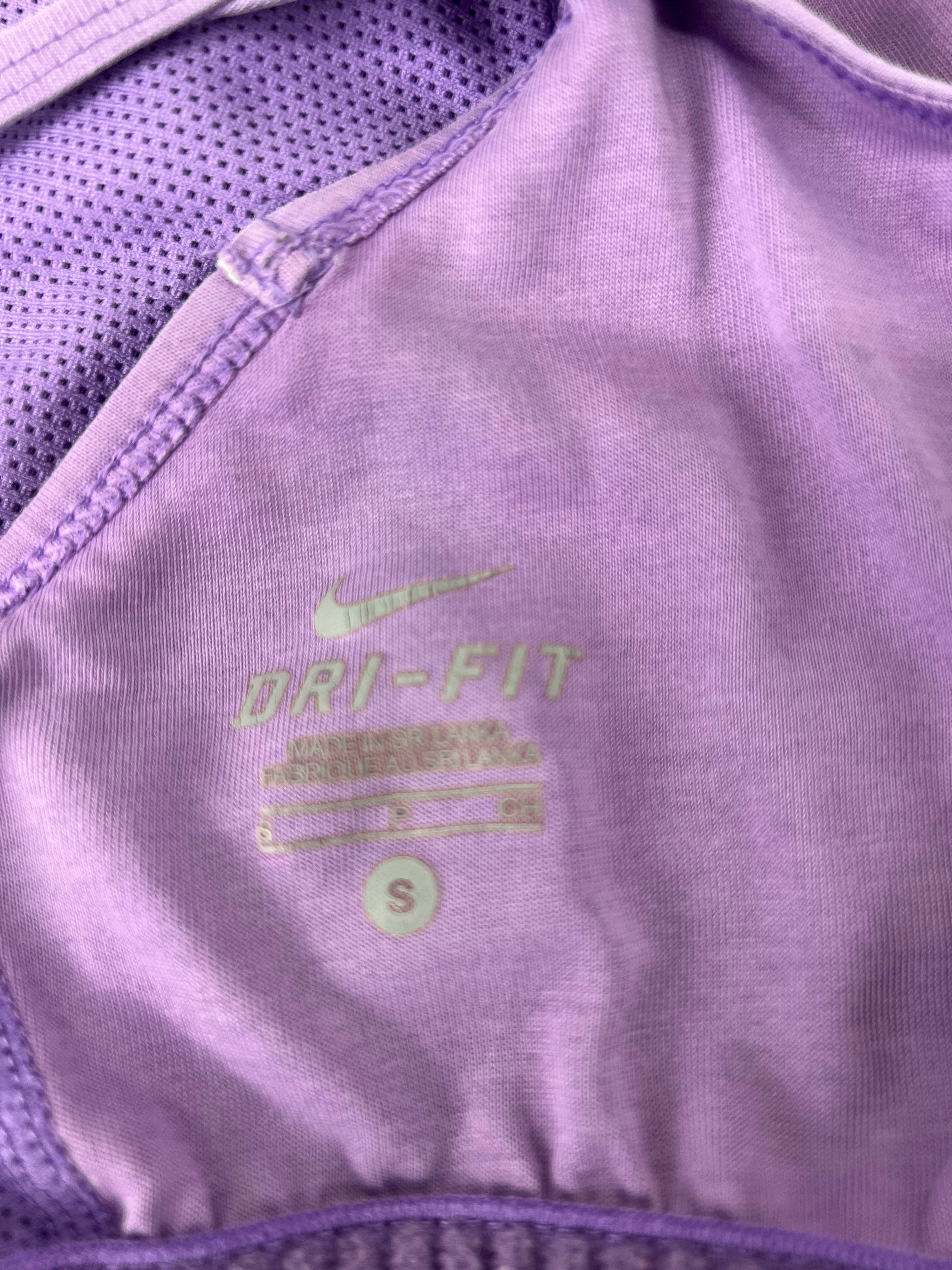 Close-up of Nike Dri-FIT label inside mauve sports vest showing size Small and fabric texture