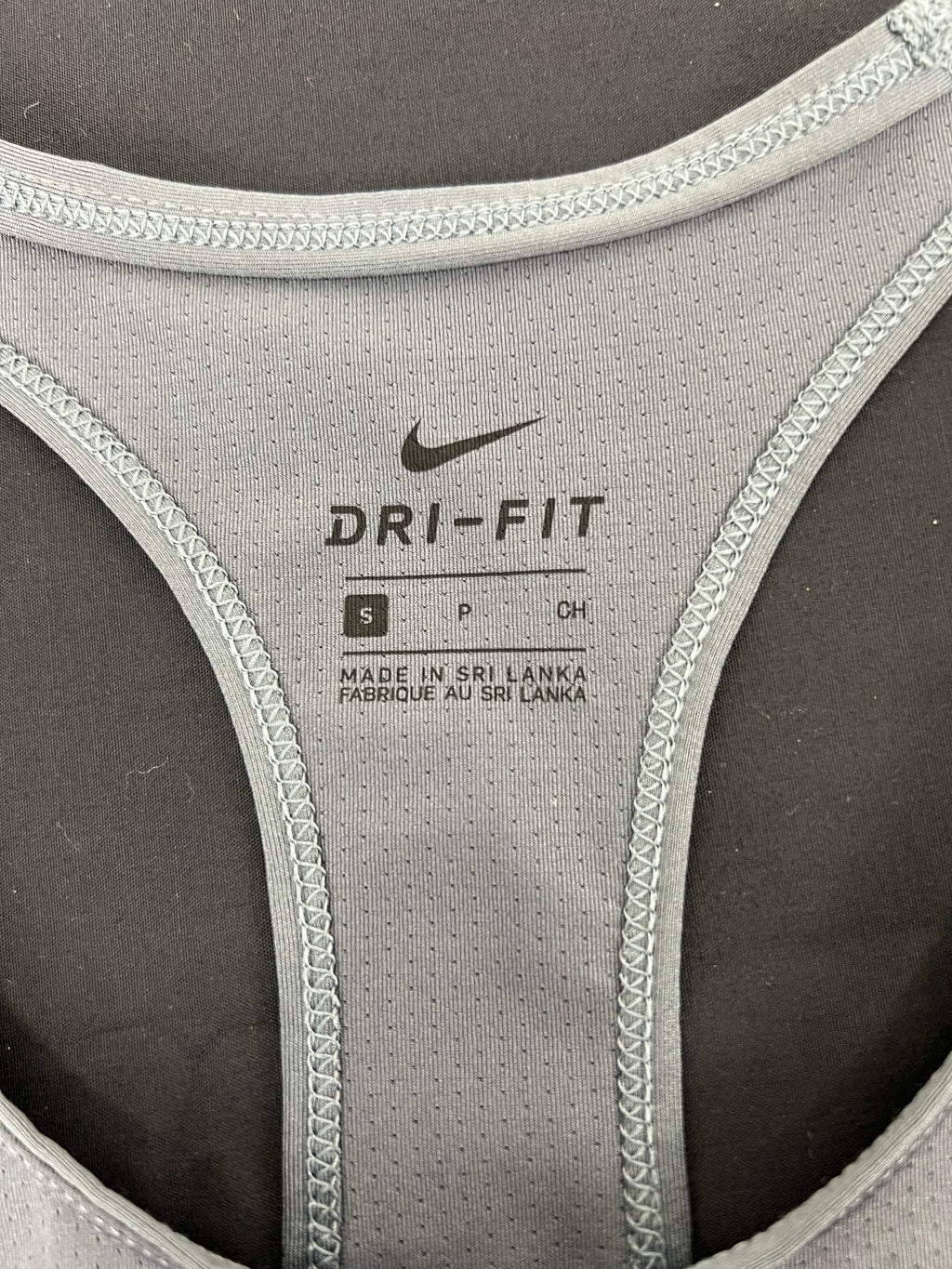 Close-up of Nike Dri-Fit label and stitching inside grey sports vest