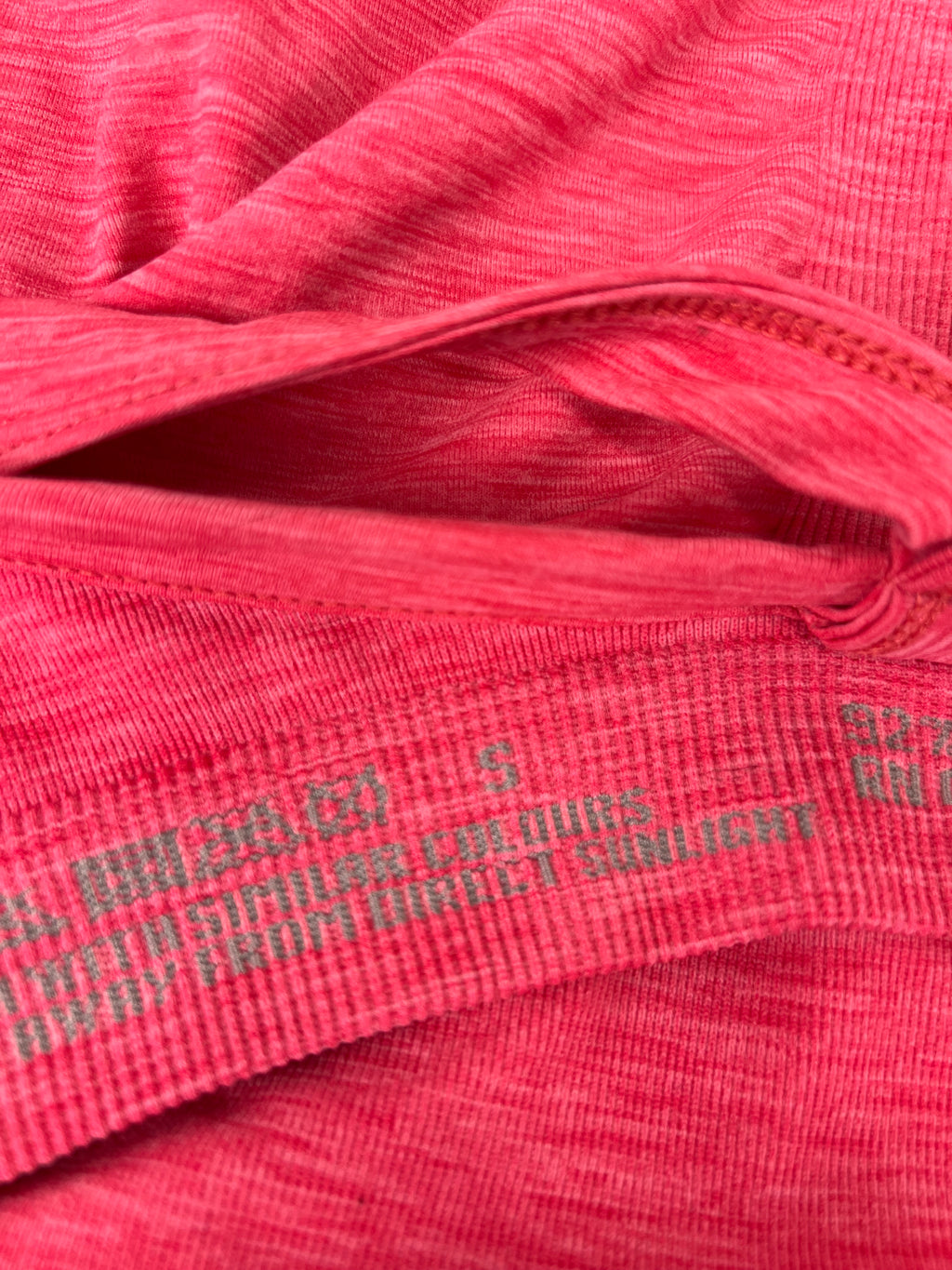Close-up of inner label and fabric texture of pink Sweaty Betty vest top