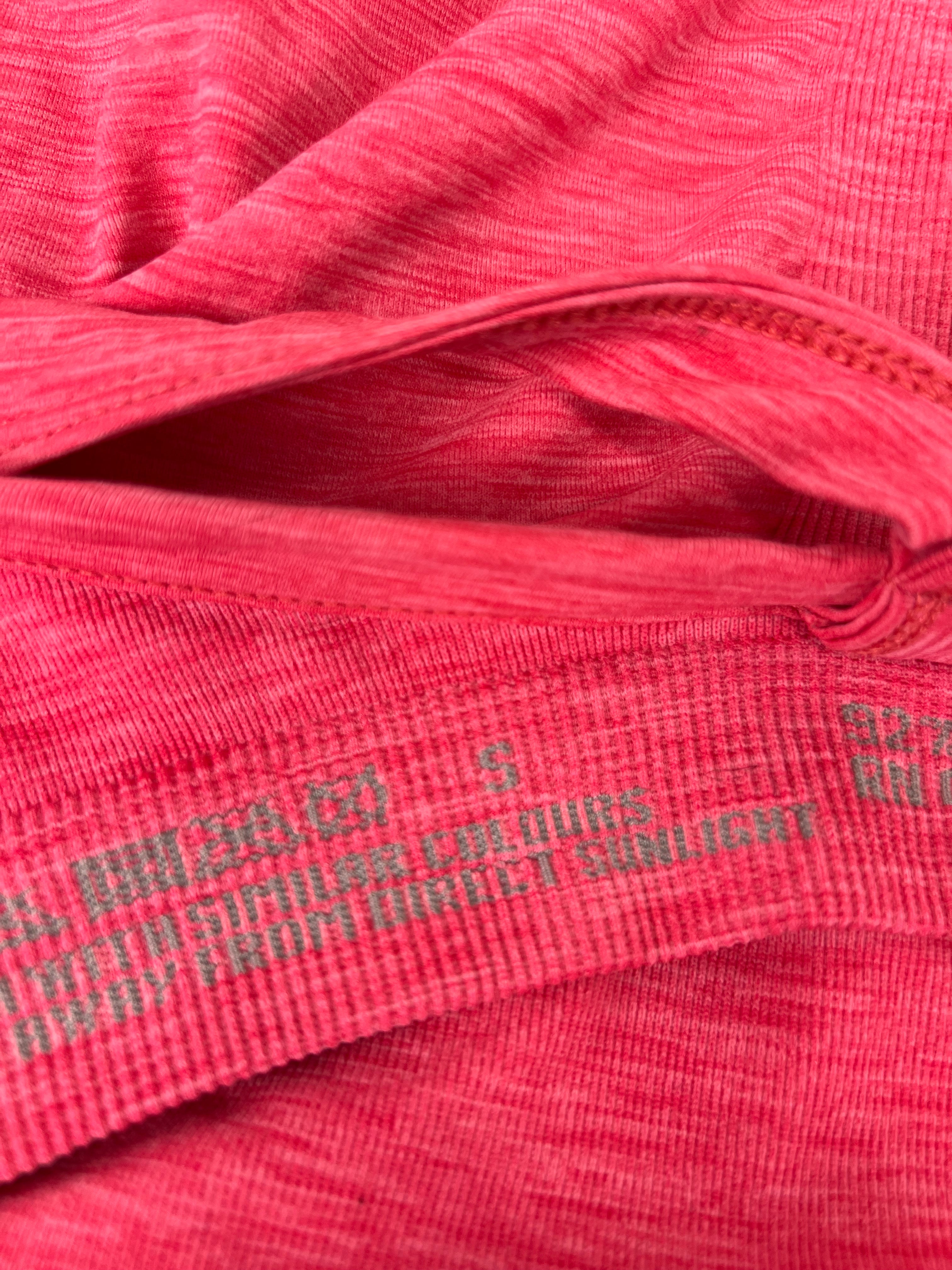 Close-up of inner label and fabric texture of pink Sweaty Betty vest top
