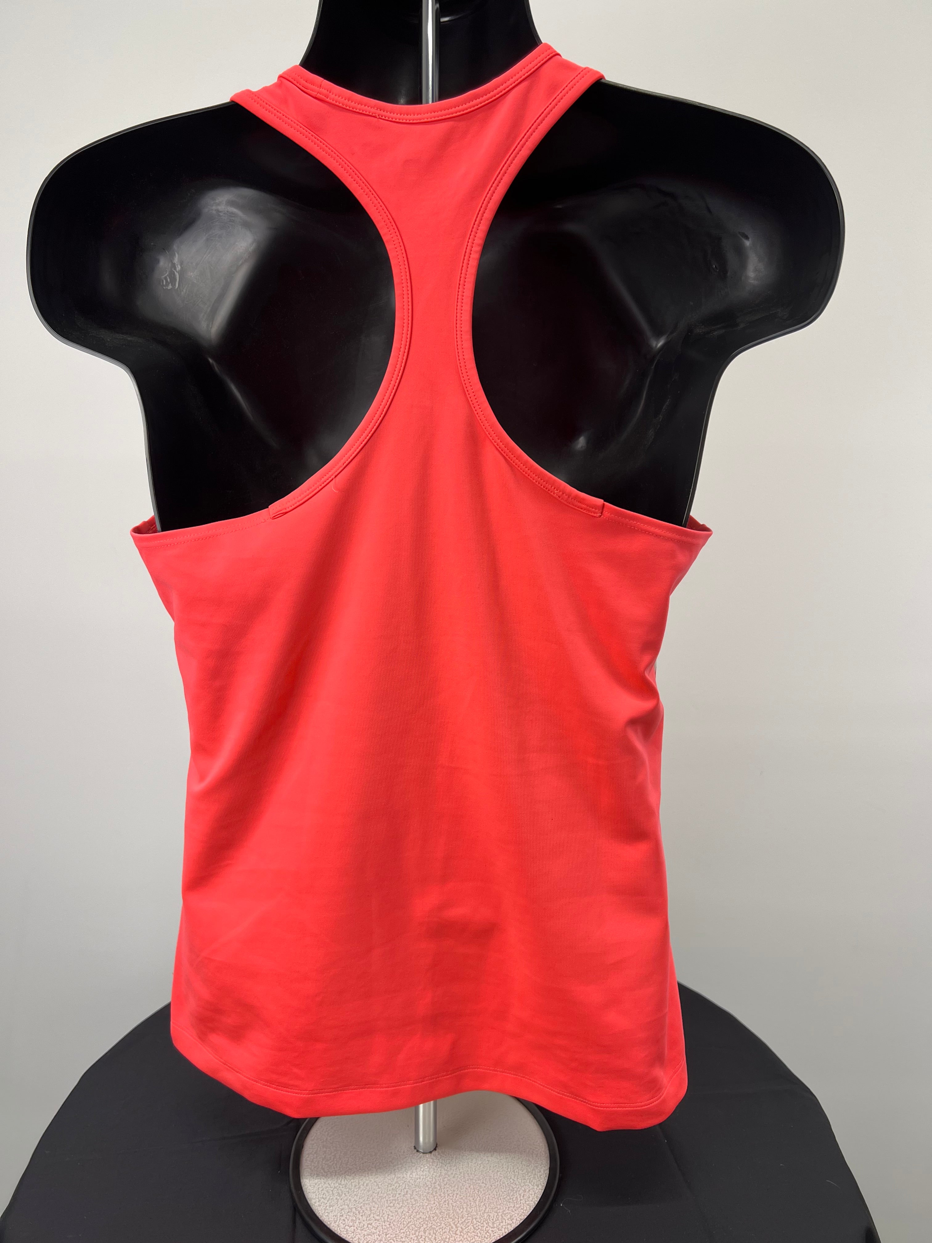 Back view of plain orange racerback adidas Stella McCartney sports vest displayed on mannequin