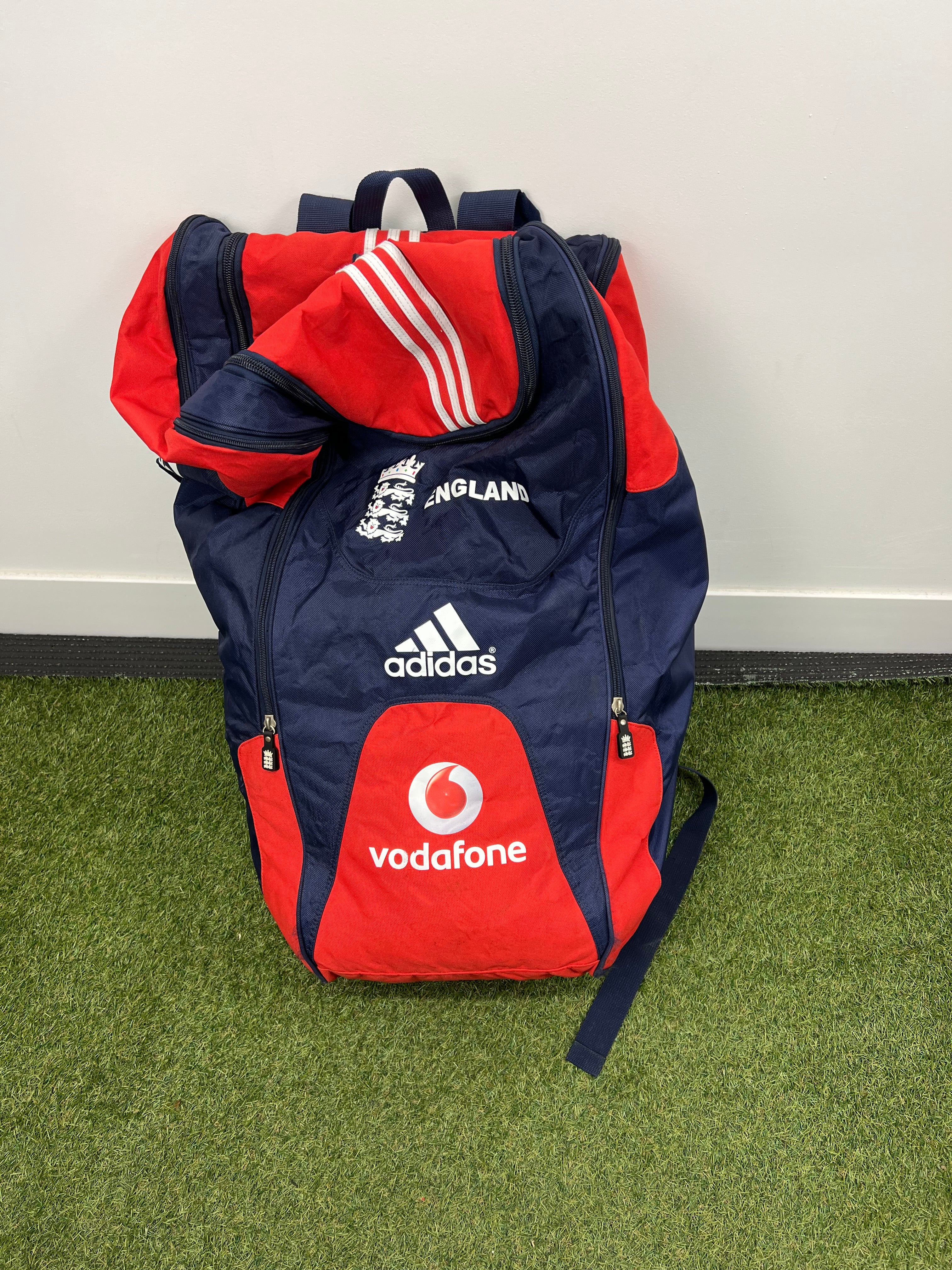 Front view of large England cricket bag in red and navy with England crest, Adidas and Vodafone logos