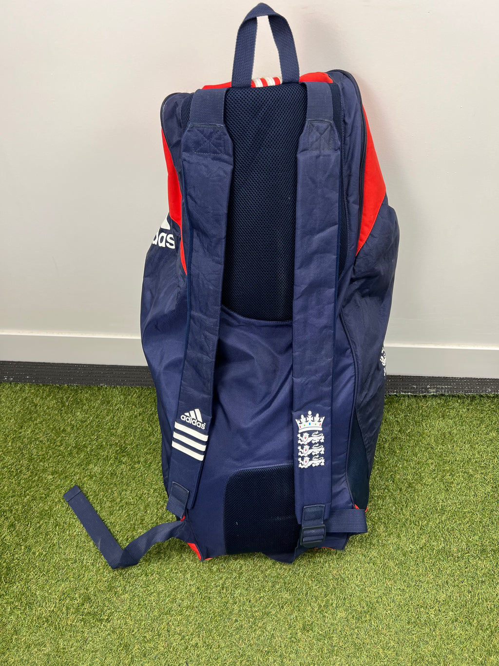 Rear view of cricket bag showing padded navy blue shoulder straps with England crest and Adidas logo