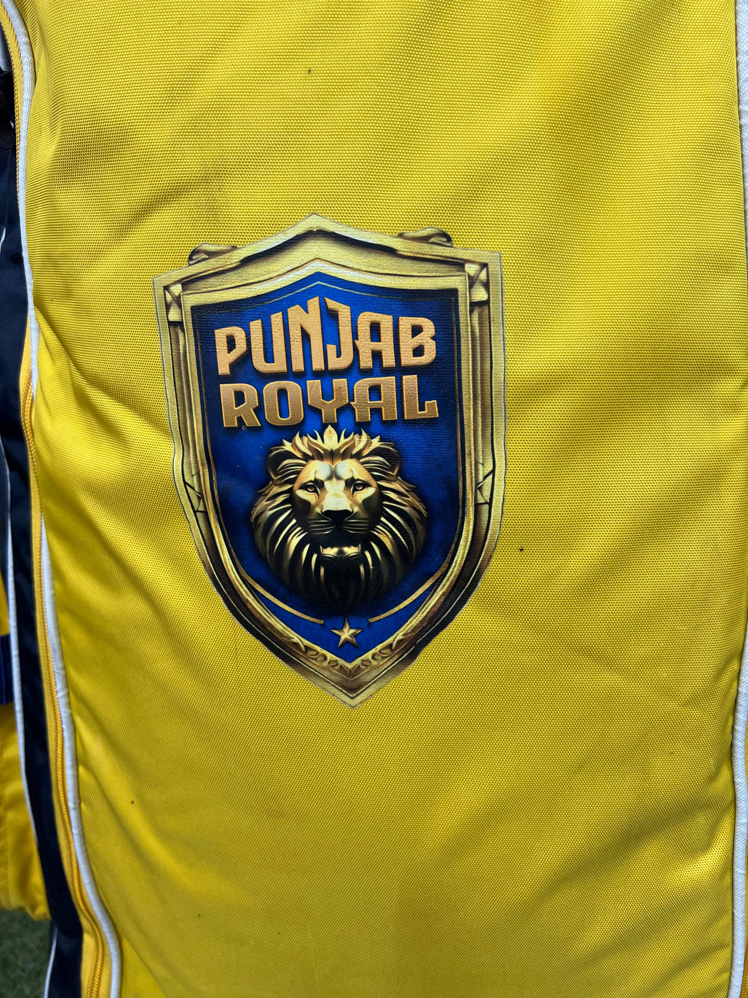 Close-up of Punjab Royal logo featuring a lion emblem on the yellow cricket bag